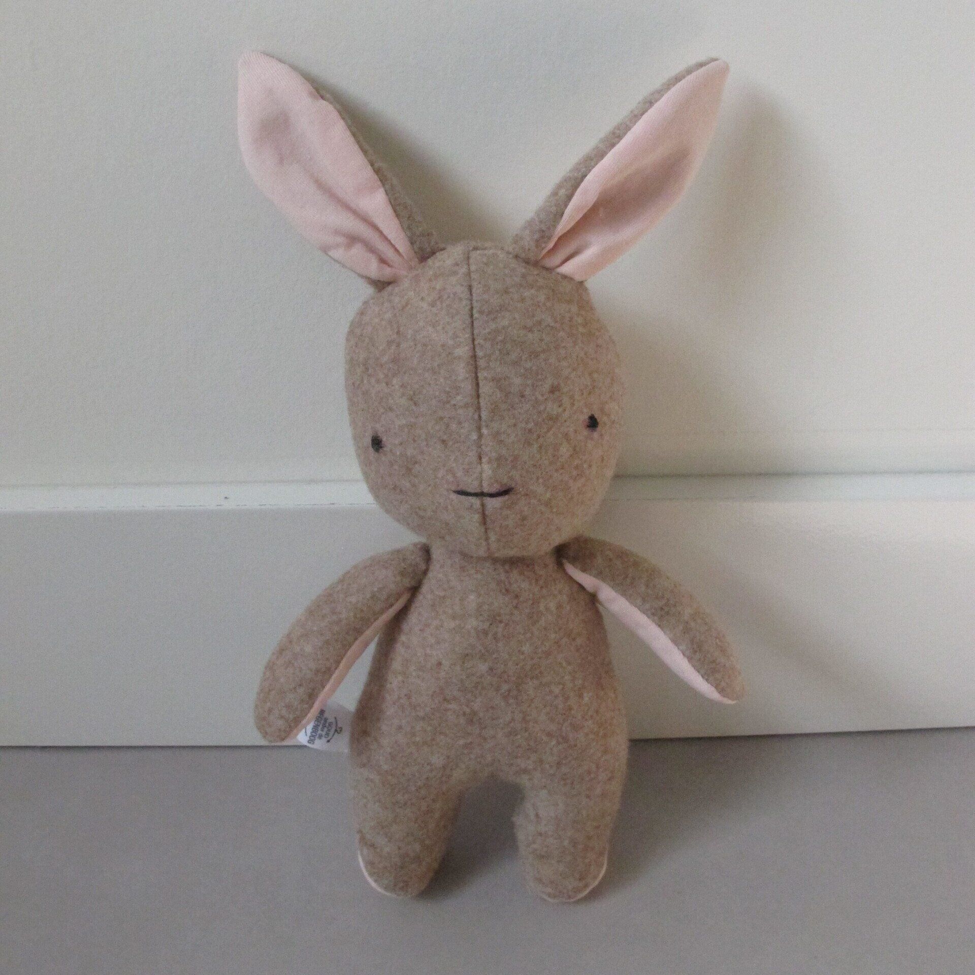 Een herinneringshaasje met roze oren zit op een tafel