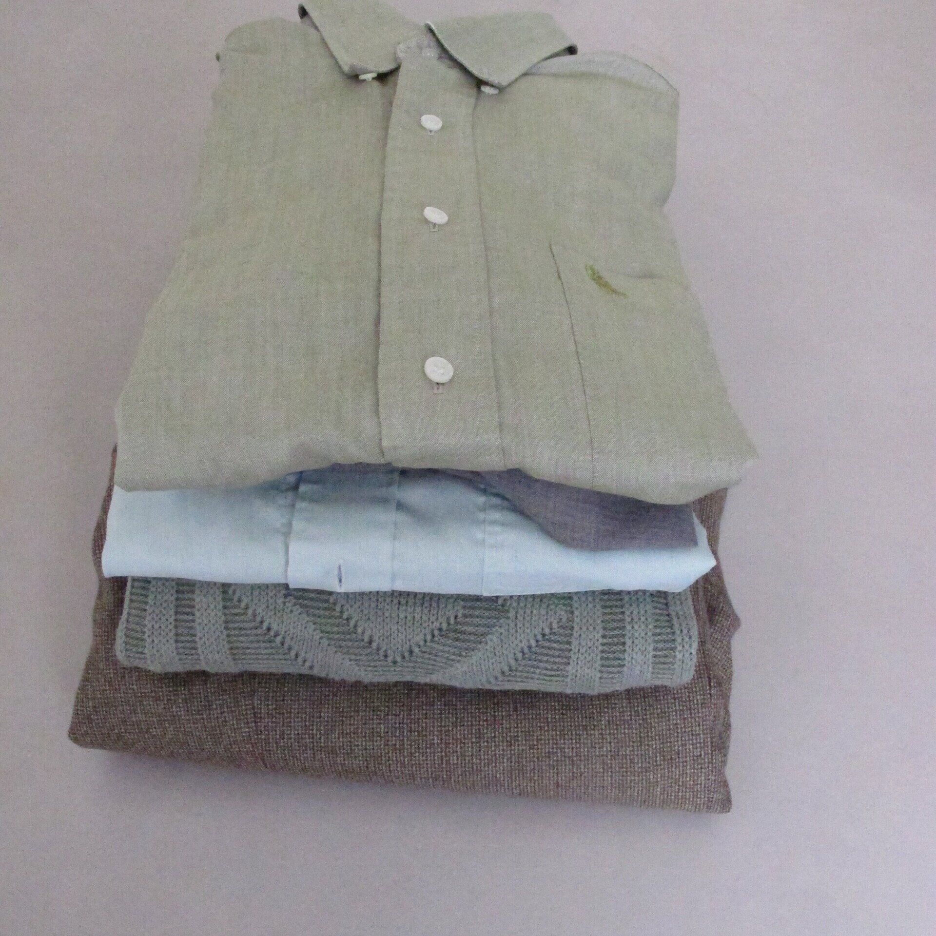 Een stapel opgevouwen kleding, waaronder een shirt en een broek