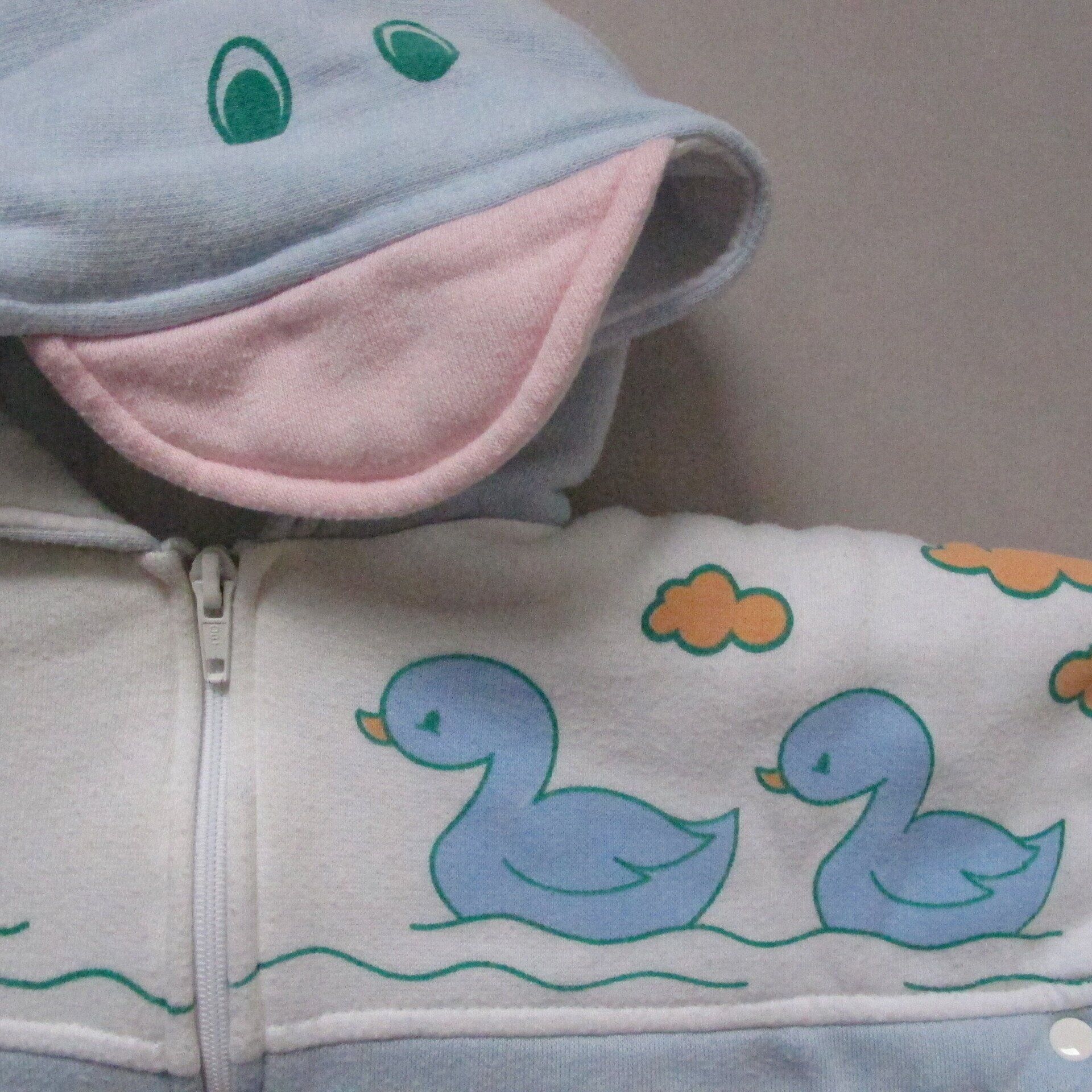 Een babyhoodie met eenden en wolken erop