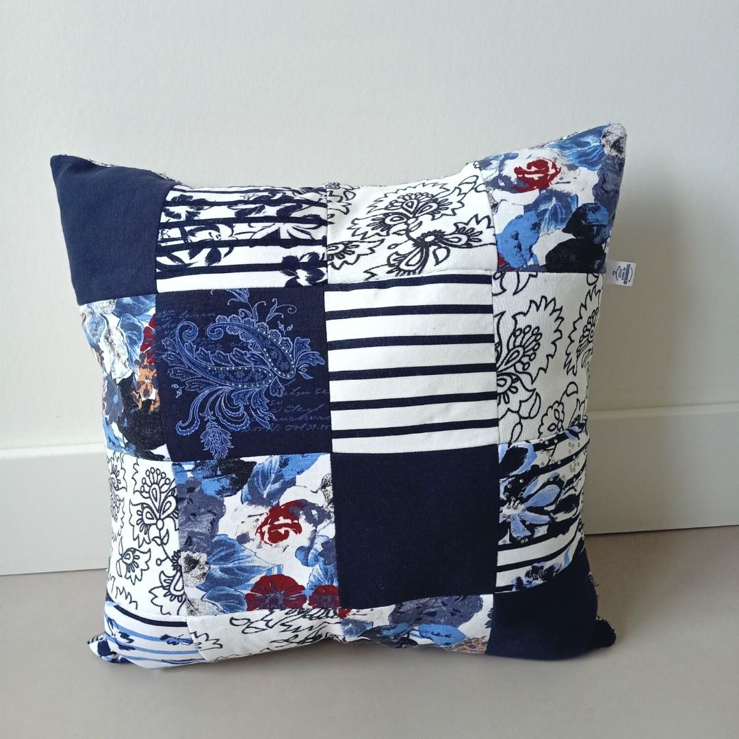 Een blauw en wit kussen ligt op de grond