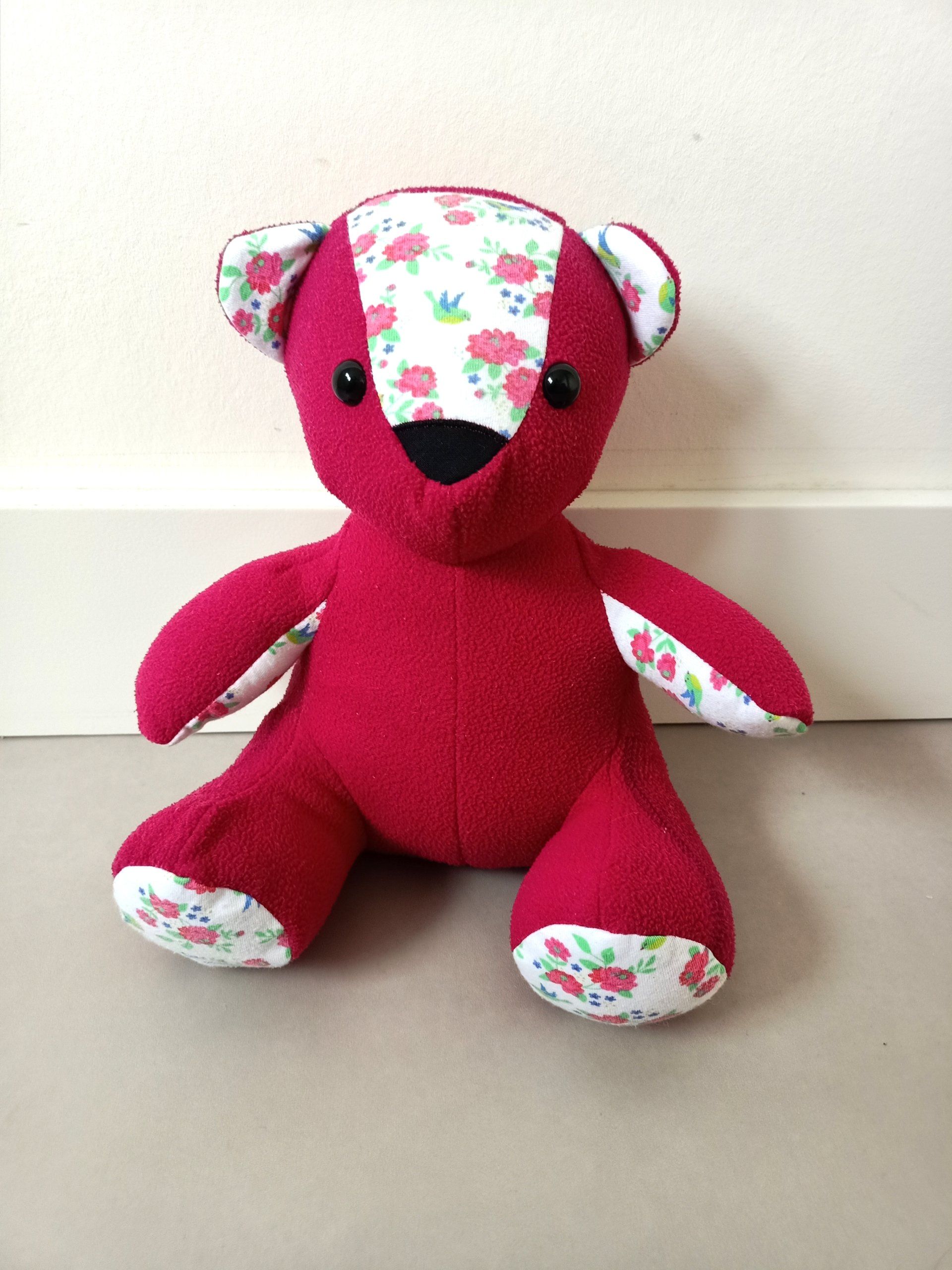 Een rode troostbeer zit op een tafel