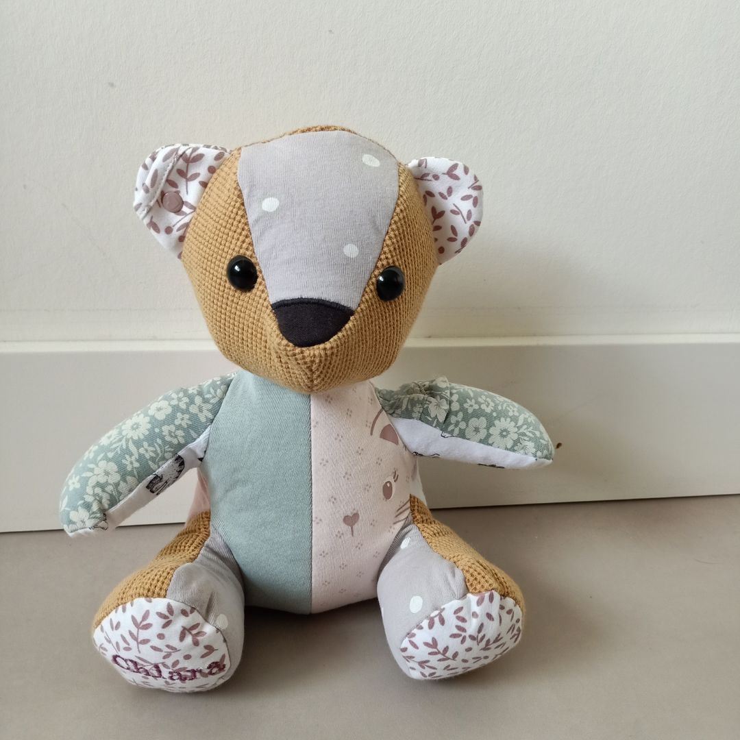 Een herinneringsbeer zit voor een witte muur