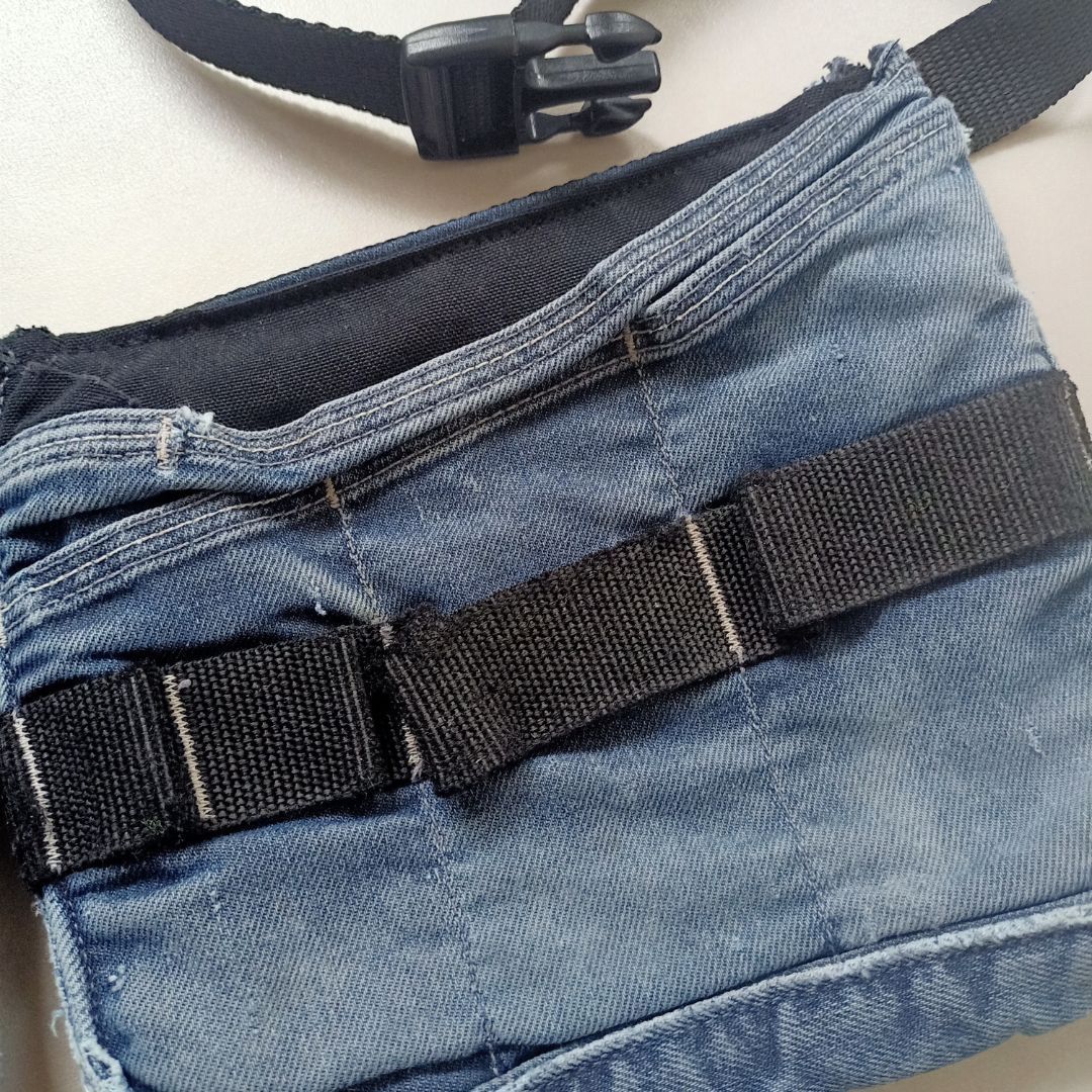 Een blauwe spijkertas met een zwarte band en gesp