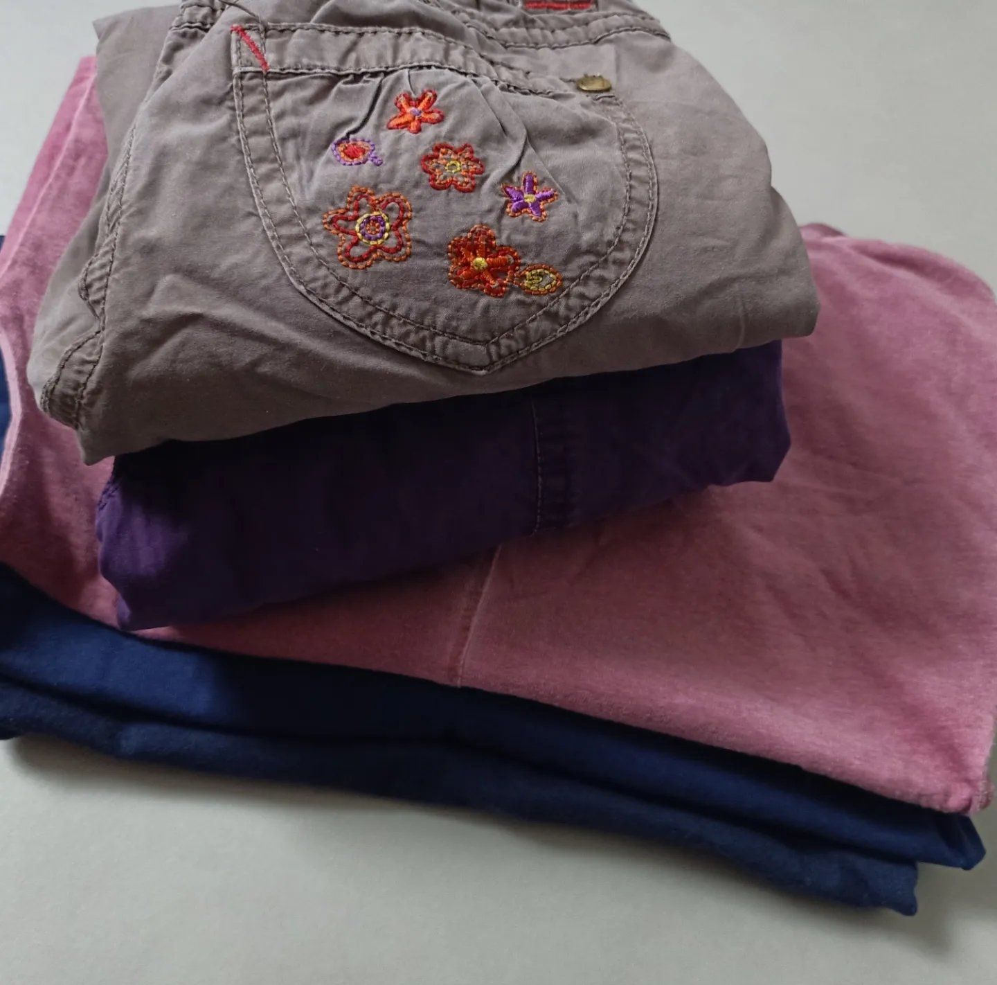 Een paars shirt met bloemen erop is op een roze shirt gestapeld