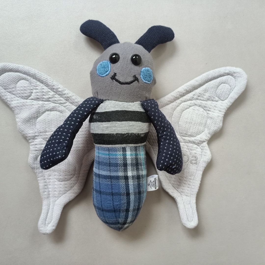 Een herinneringsvlinder met een label gemaakt van kleding van een overleden opa