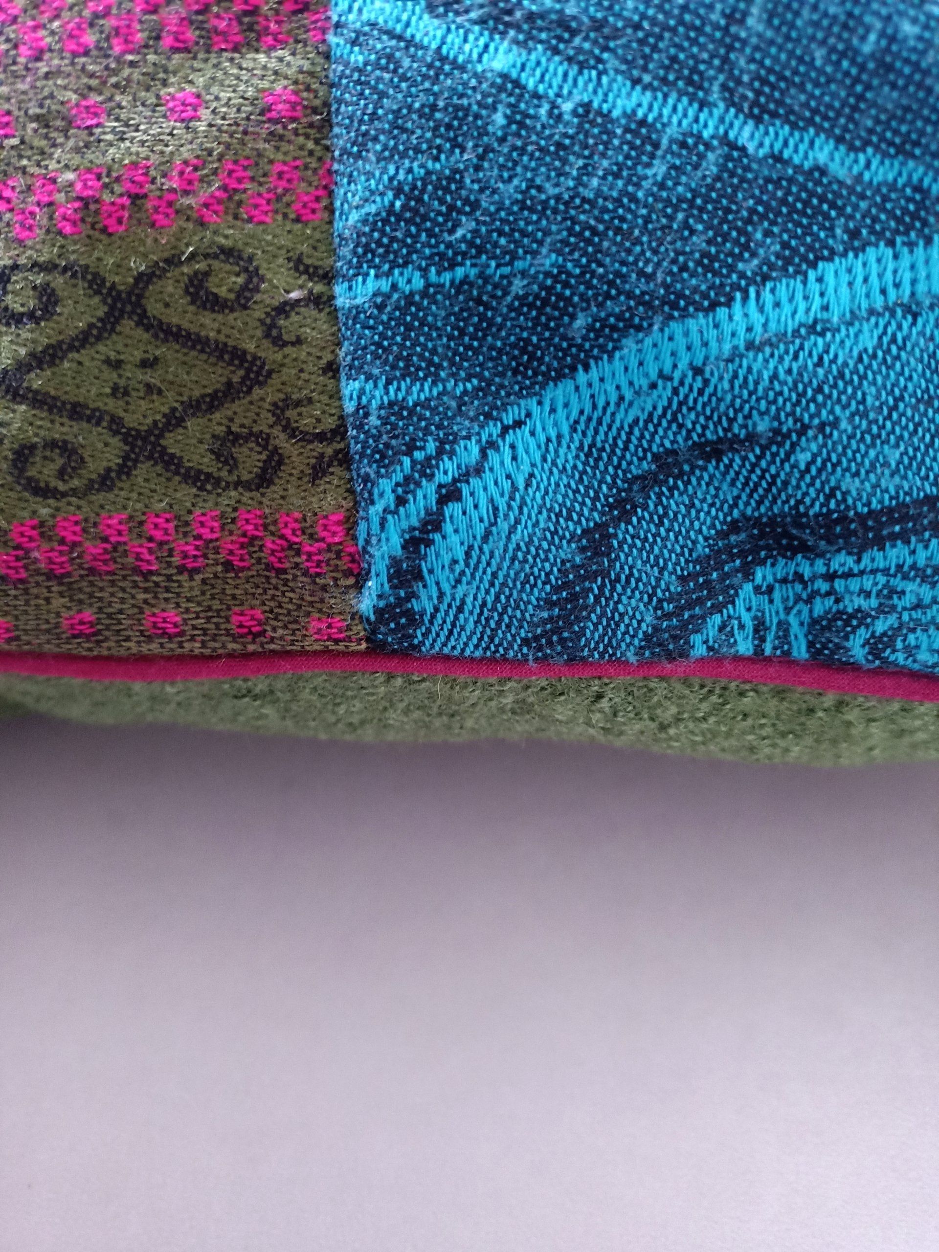 Een close-up van een blauw en roze troostkussen op een tafel.