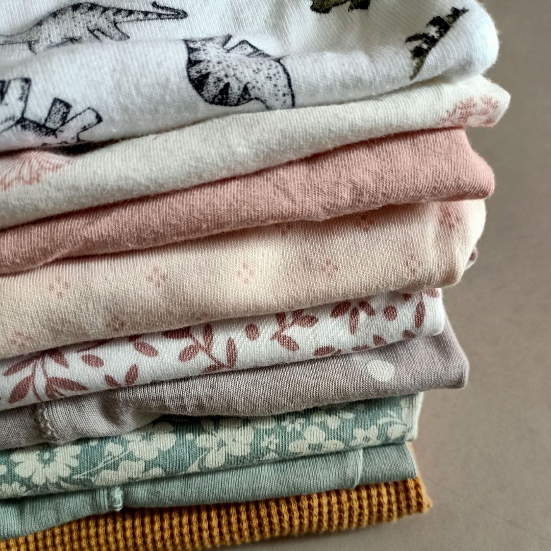 Een close-up van een stapel kleding op een tafel.