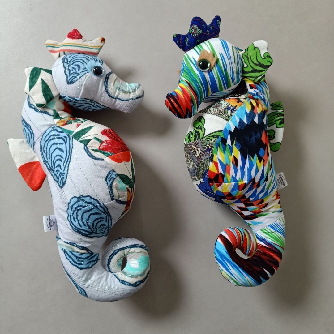 Twee zeepaardjes zitten naast elkaar op een tafel en zijn gemaakt van de kleding van een overleden moeder