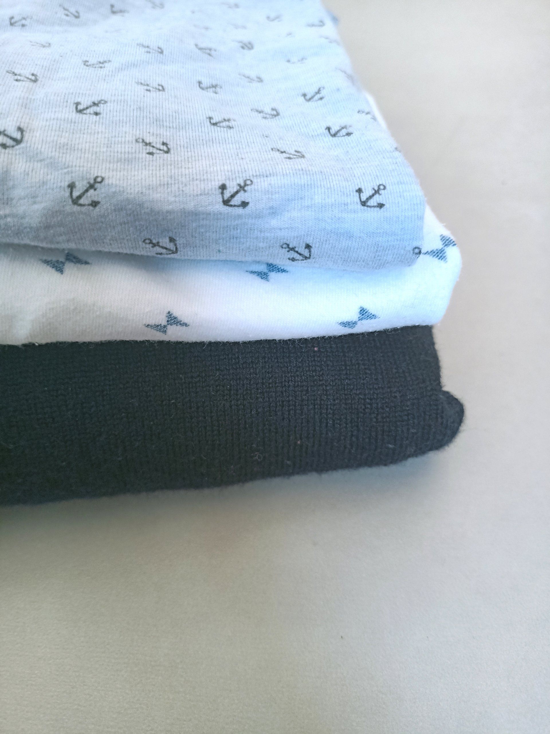Een stapel kleding met ankers erop