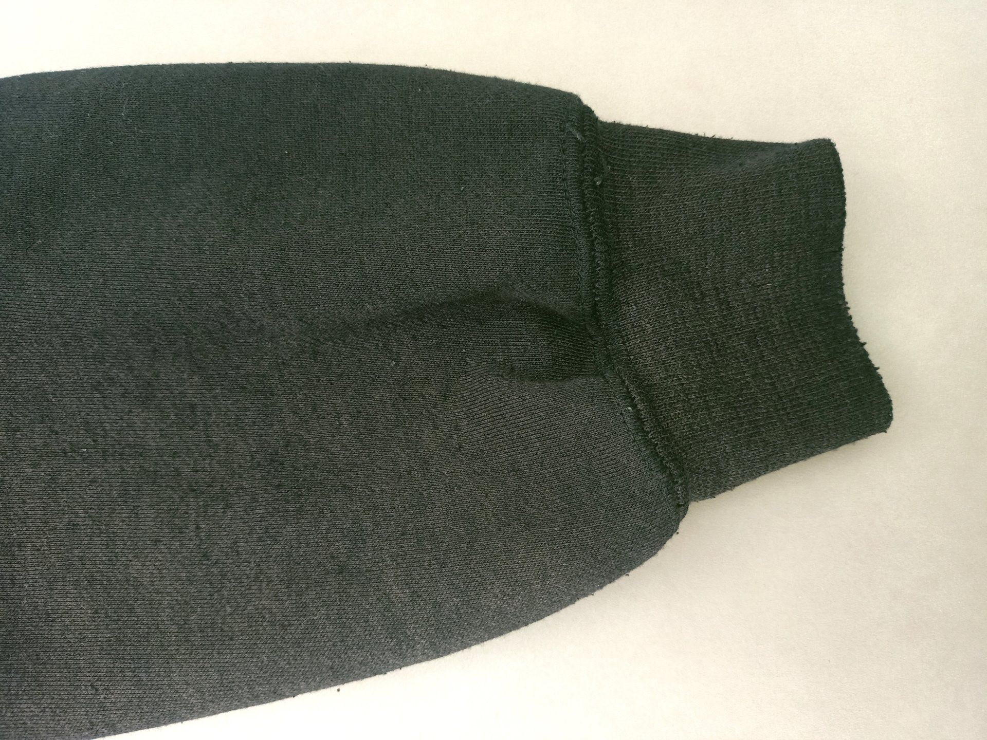 Een close-up van een zwarte trui mouw