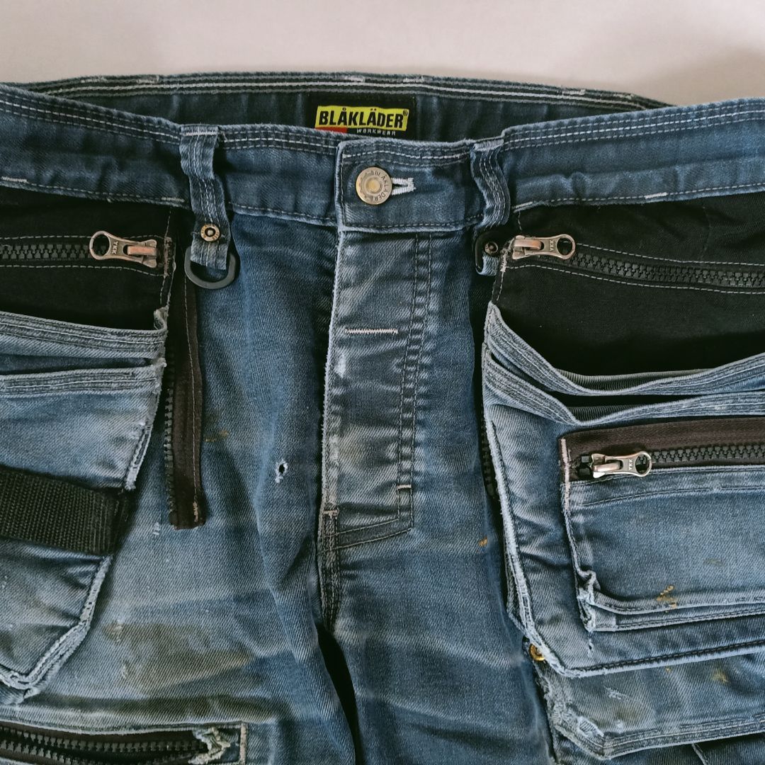 Een spijkerbroek met zwarte ritszakken