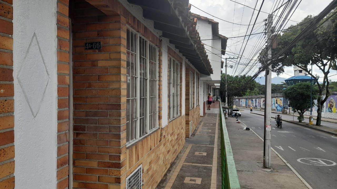 Un edificio de ladrillo con muchas ventanas está al lado de una calle.