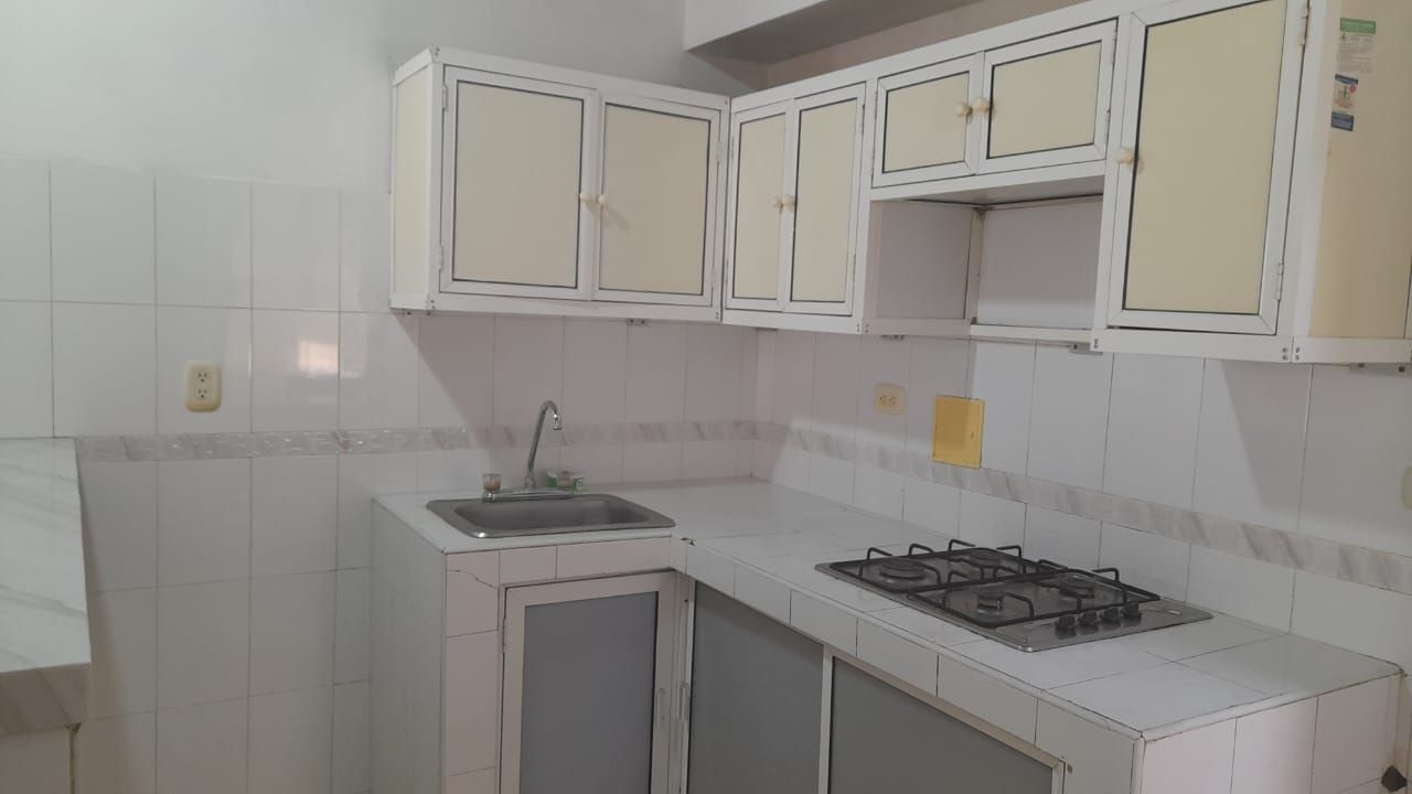 Una cocina con gabinetes blancos y un horno de estufa.