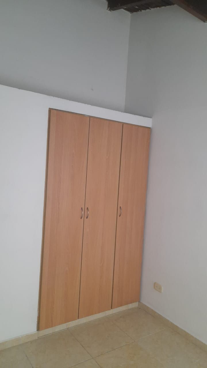 Una habitación vacía con armarios de madera en la pared.