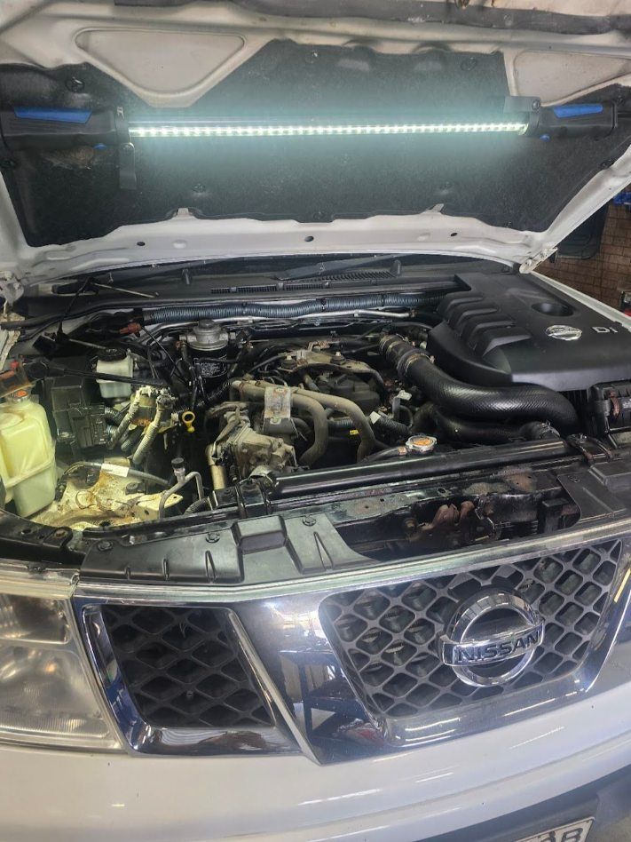 The Hood Of A White Nissan Is Open And The Engine Is Visible — Nuron Inspection & Service Centre In Broadmeadow, NSW