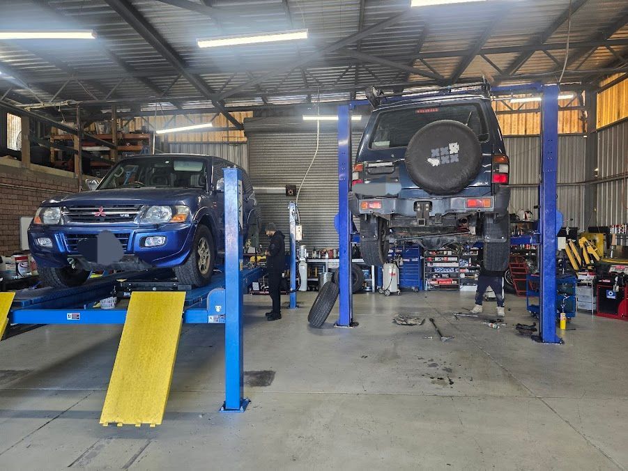 A Blue Car Is On A Lift In A Garage — Nuron Inspection & Service Centre In Broadmeadow, NSW