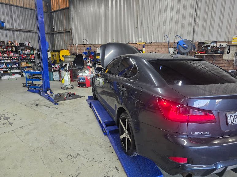 A Gray Lexus Is Parked On A Lift In A Garage — Nuron Inspection & Service Centre In Broadmeadow, NSW