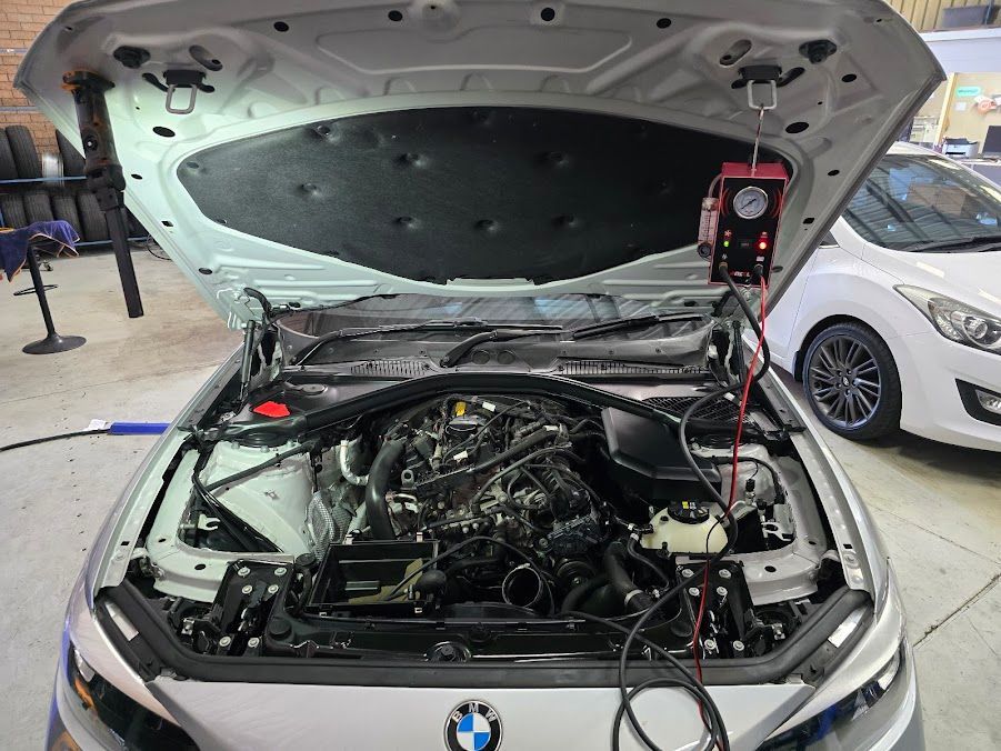 The Hood Of A BMW Is Open And The Engine Is Being Examined — Nuron Inspection & Service Centre In Broadmeadow, NSW