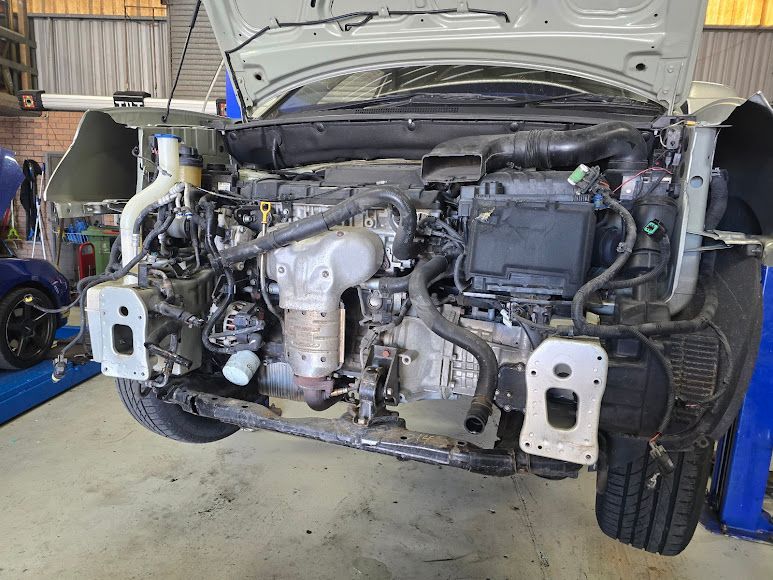 The Engine Of A Car Is Being Removed In A Garage — Nuron Inspection & Service Centre In Broadmeadow, NSW