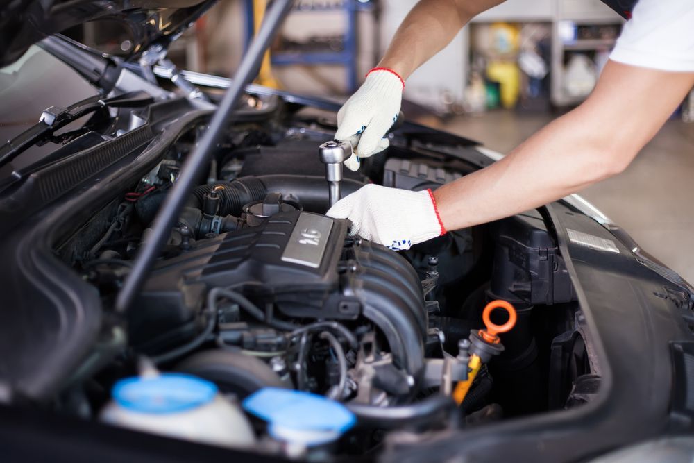 A Man Is Working On The Engine Of A Car In A Garage — Nuron Inspection & Service Centre In Broadmeadow, NSW