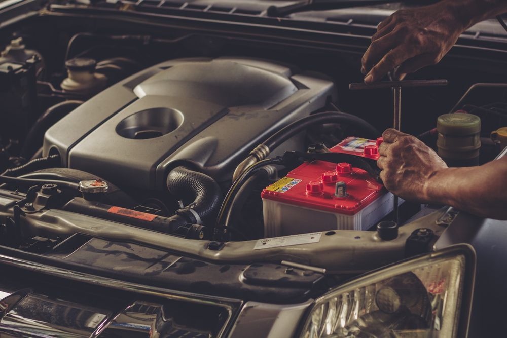 A Man Is Working On The Engine Of A Car With A Wrench — Nuron Inspection & Service Centre In Broadmeadow, NSW