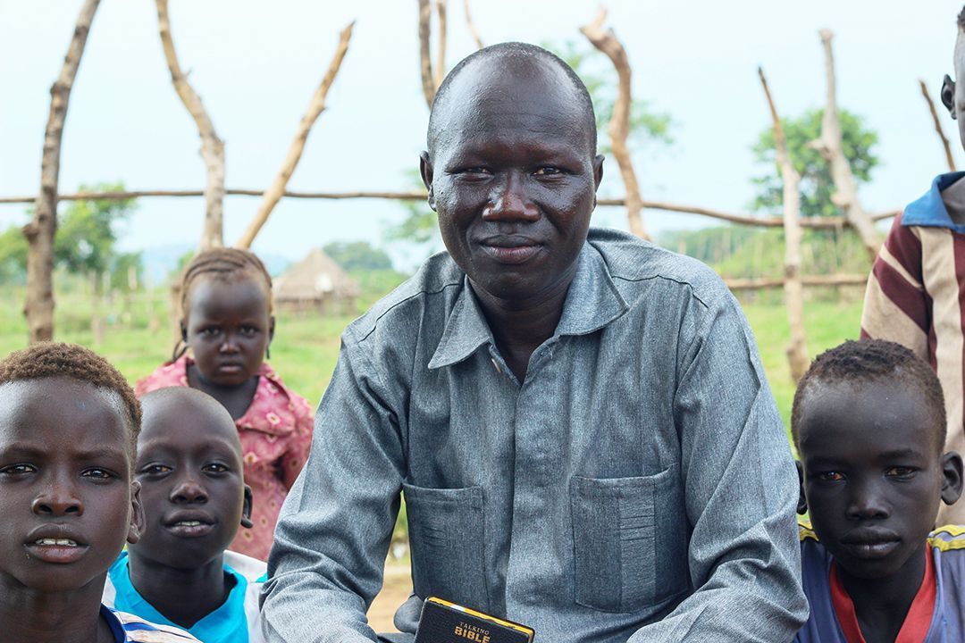 Man holding Talking Bible with children