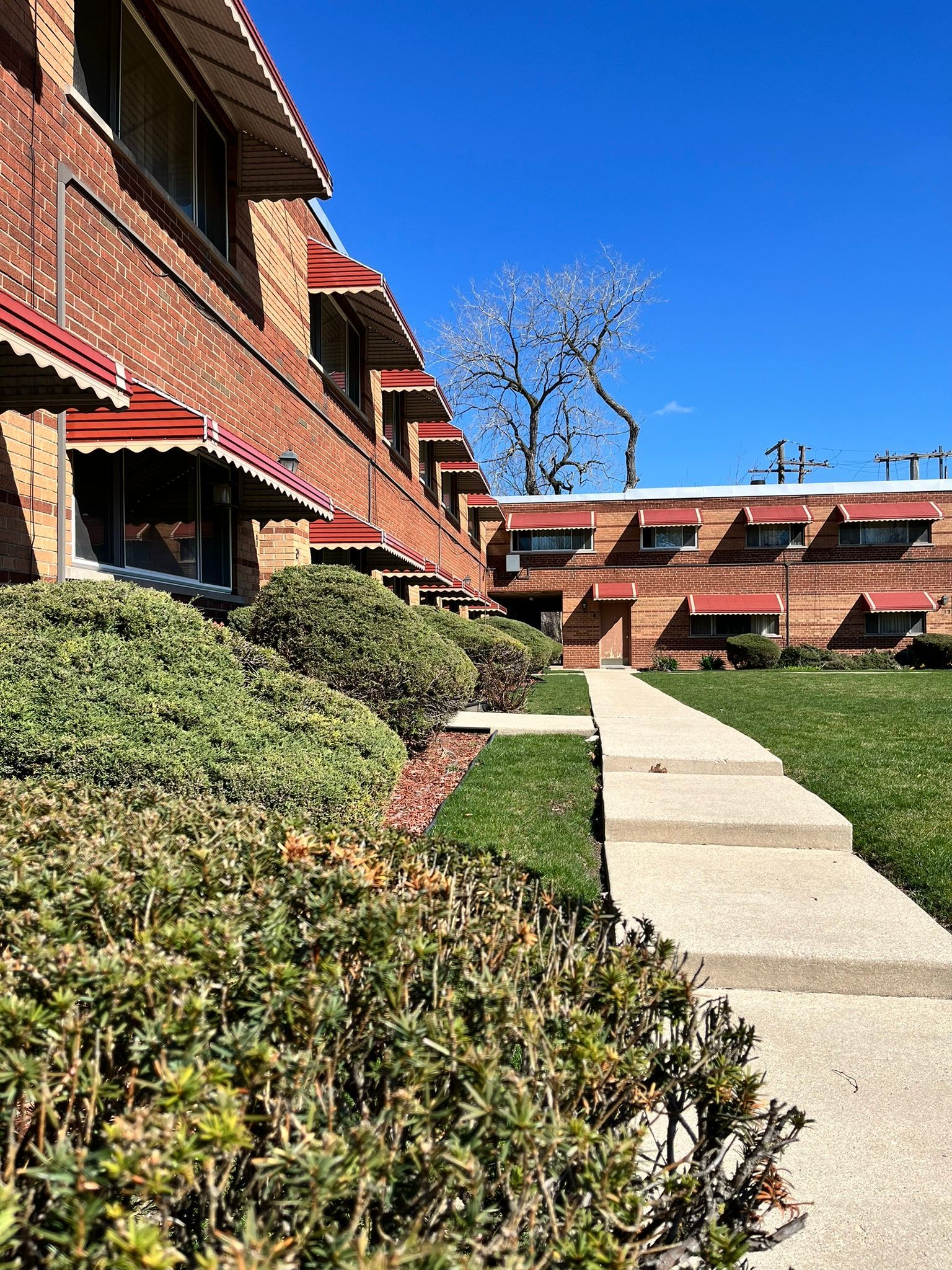 a brick apartment building with a walkway leading to it .