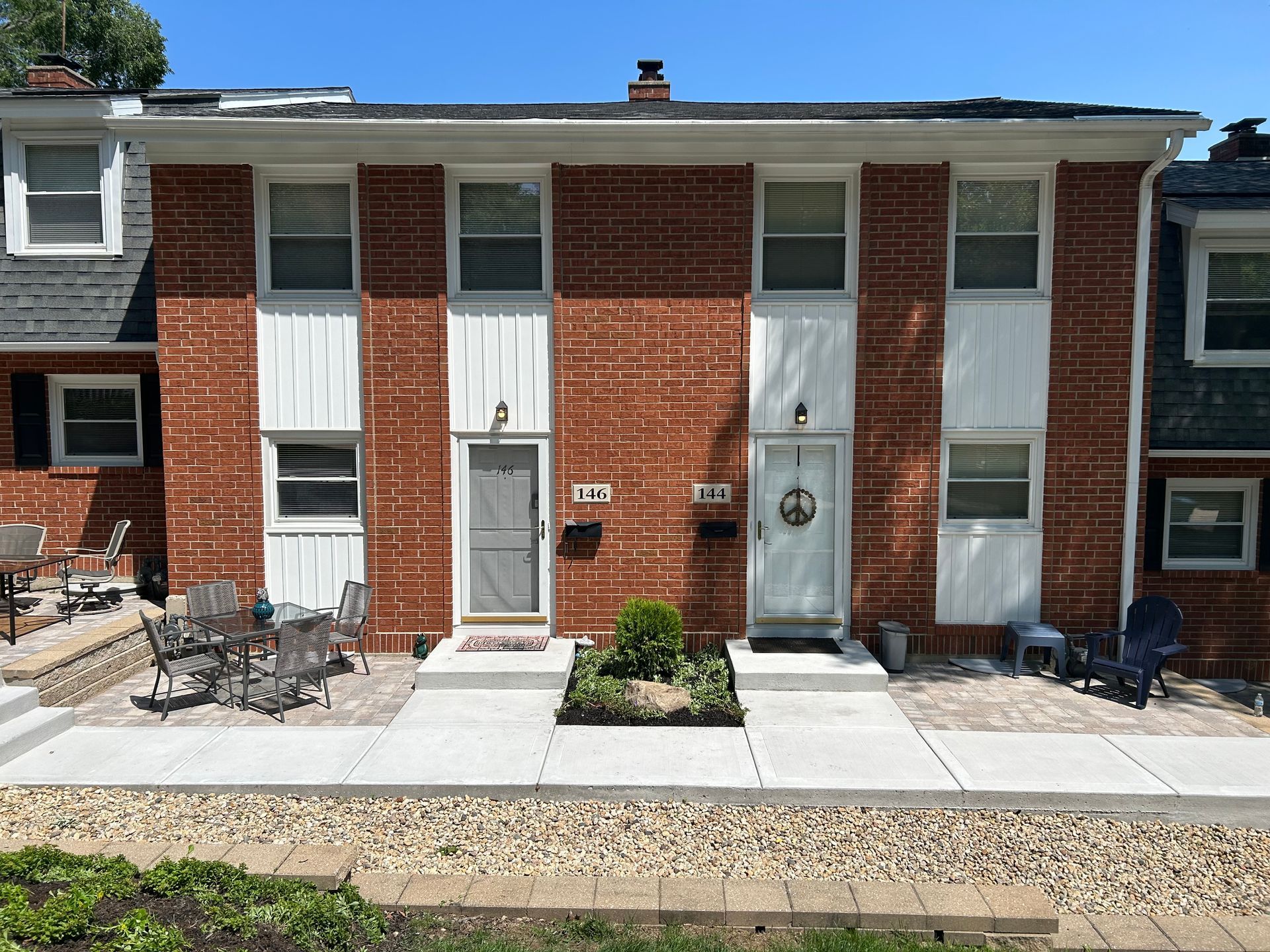 a brick apartment building with a patio in front of it