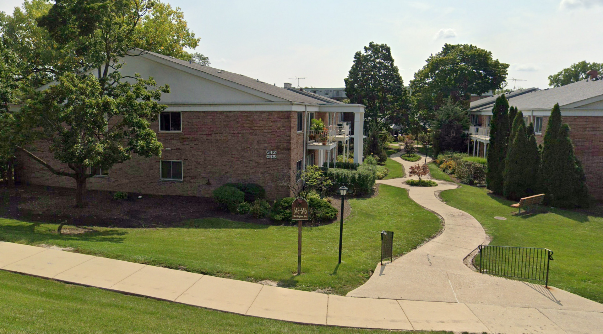 a brick apartment building with a walkway leading to it
