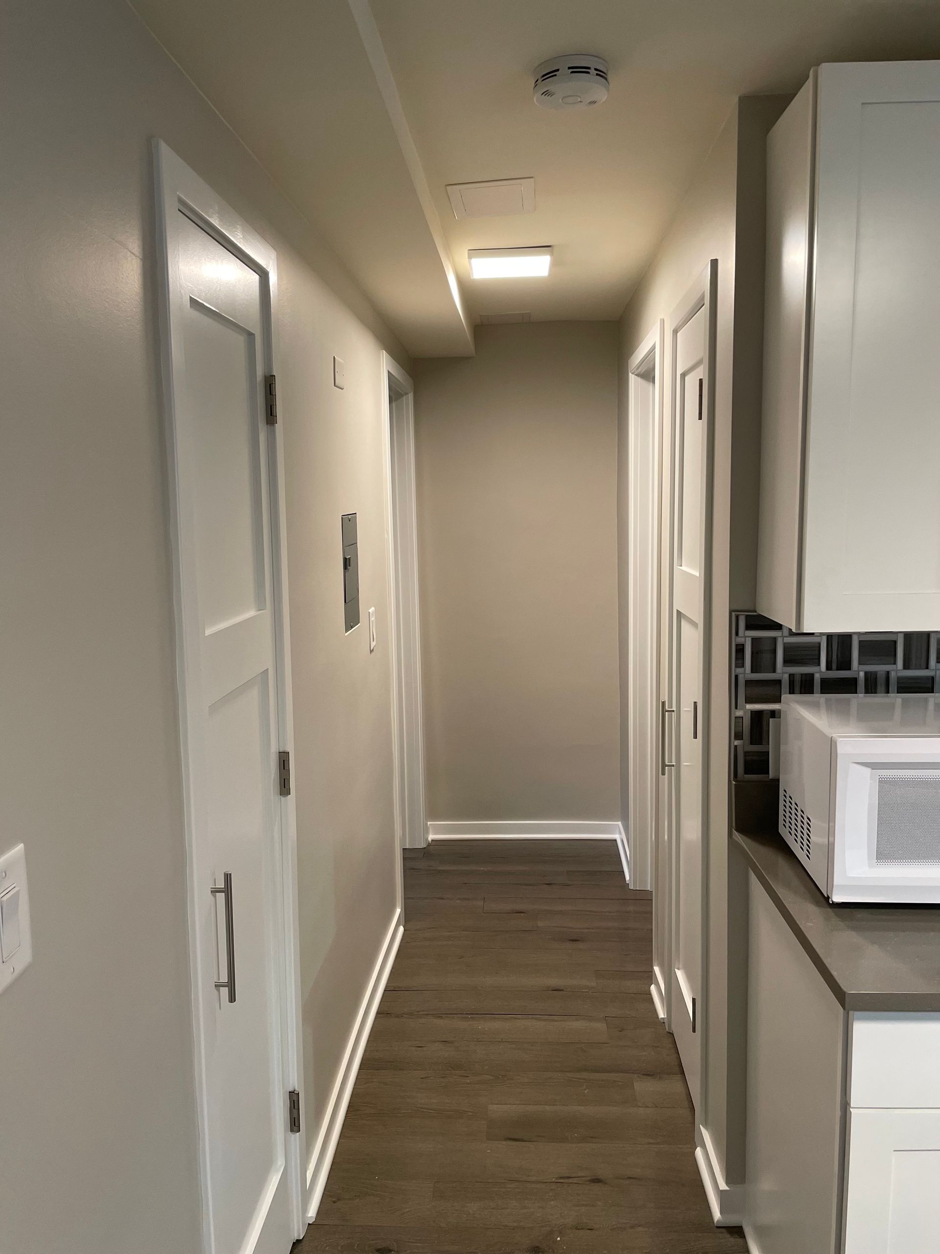 a long hallway with a microwave on the counter