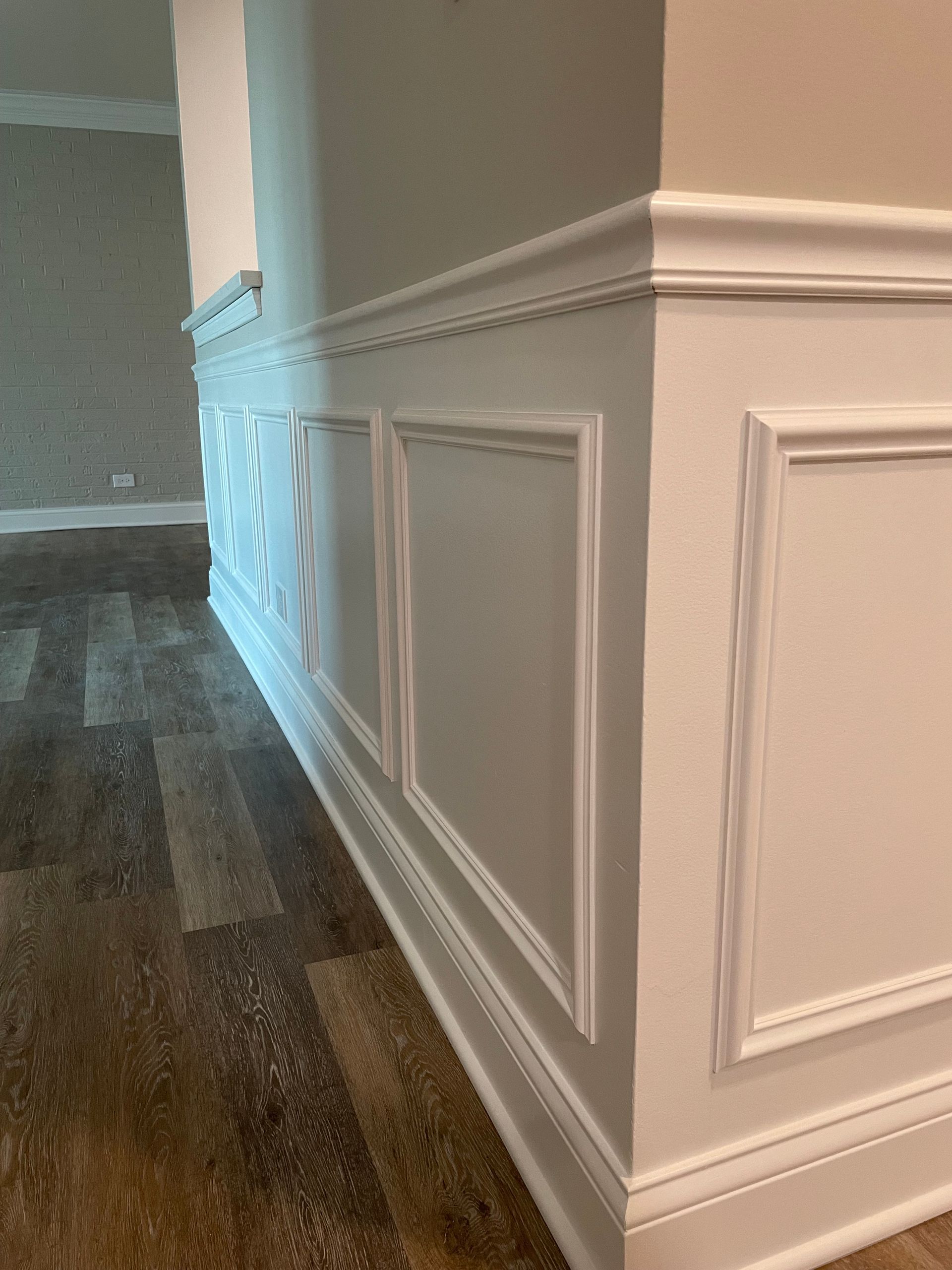 a room with a wooden floor and white trim on the walls .