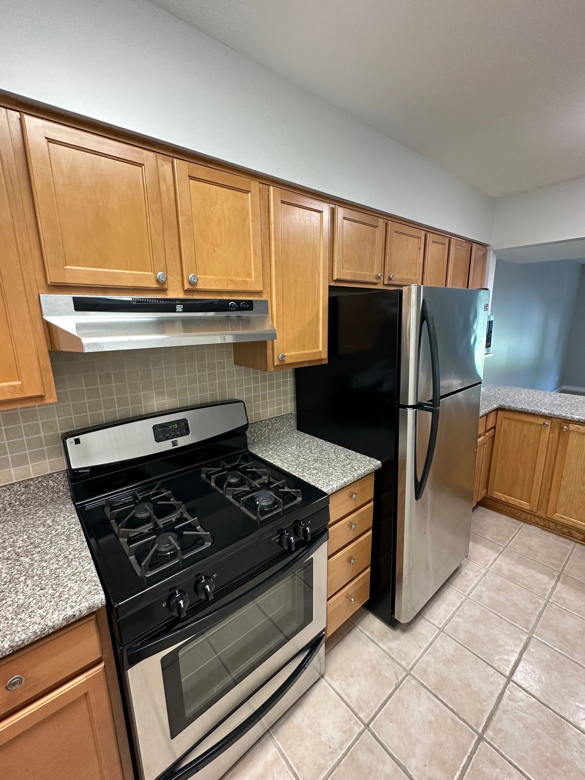 a kitchen with a stove , refrigerator , and cabinets .