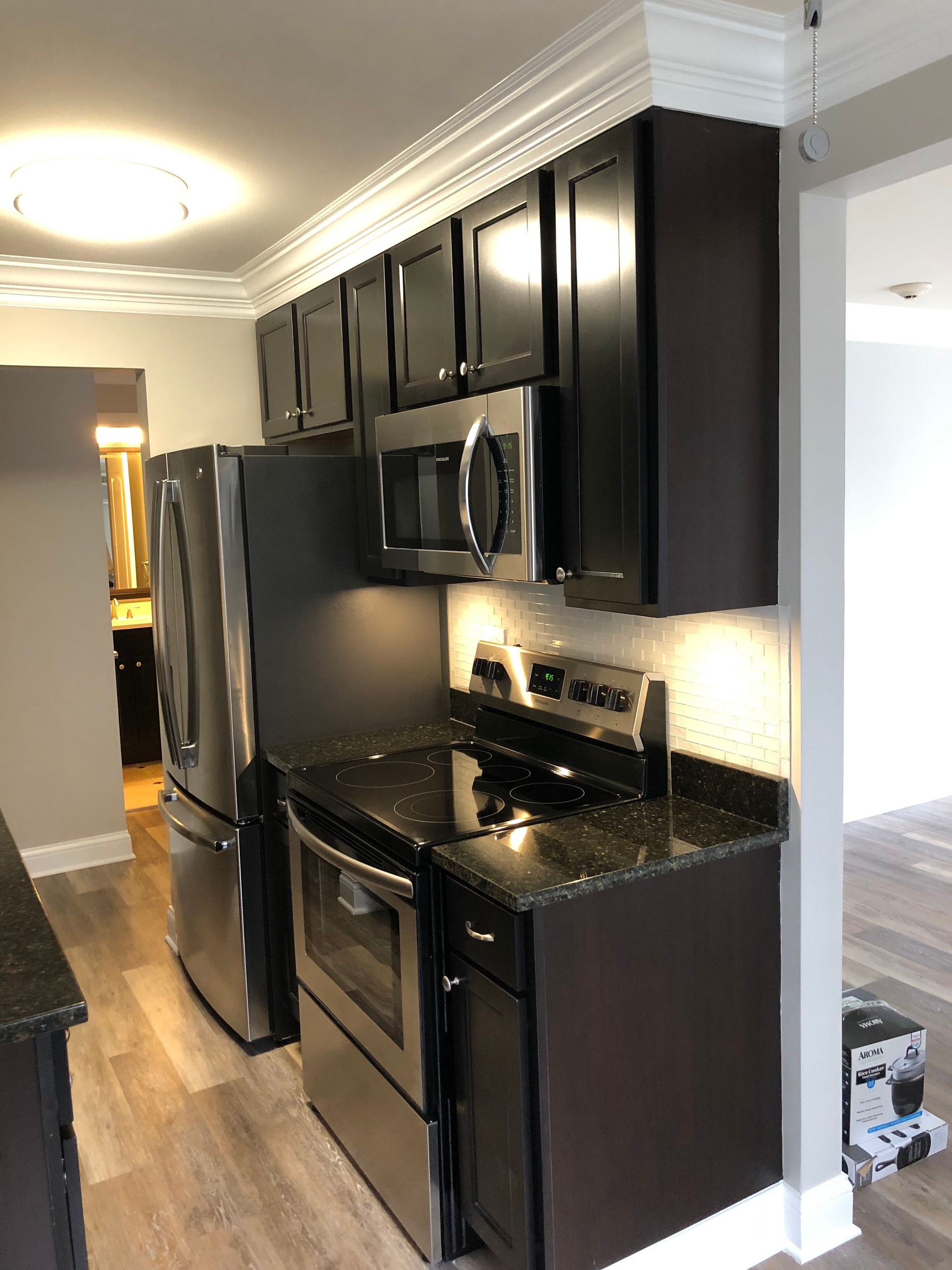 a kitchen with stainless steel appliances and black cabinets