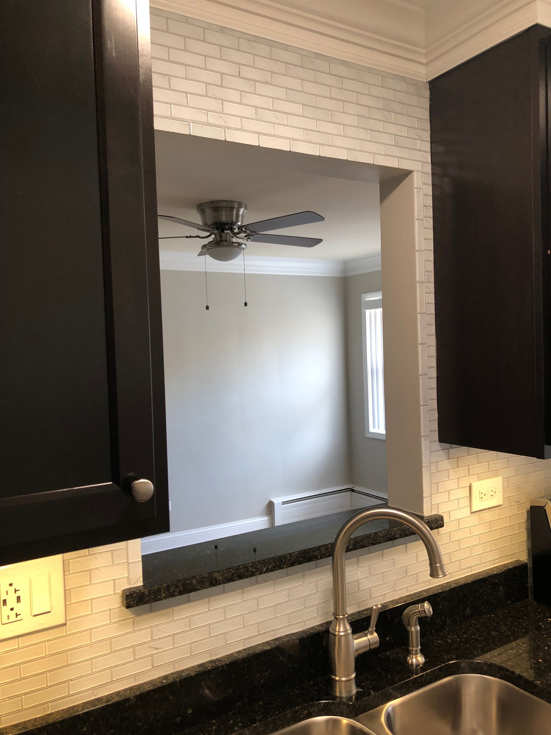 a kitchen with a sink and a ceiling fan