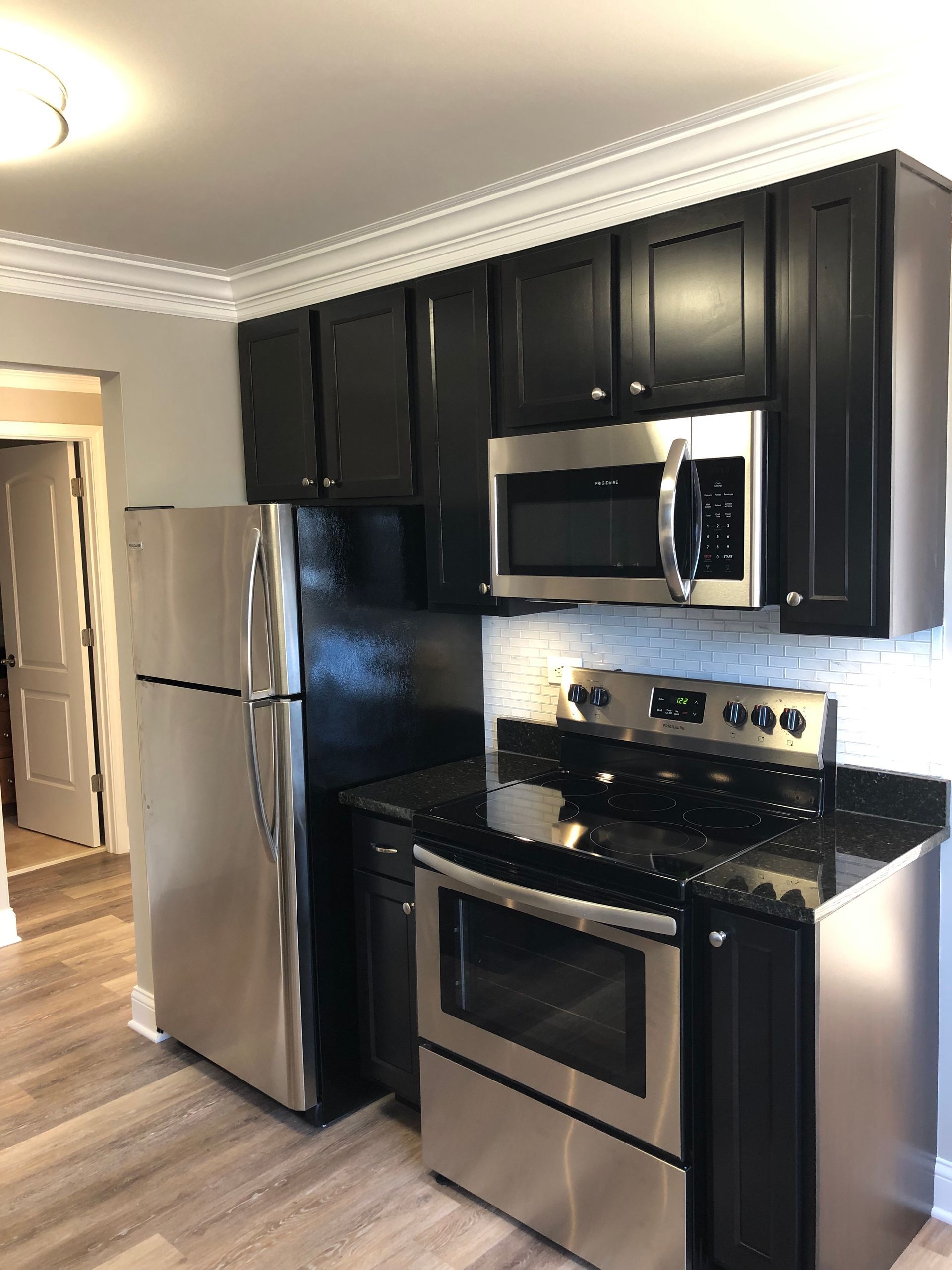 a kitchen with stainless steel appliances and black cabinets