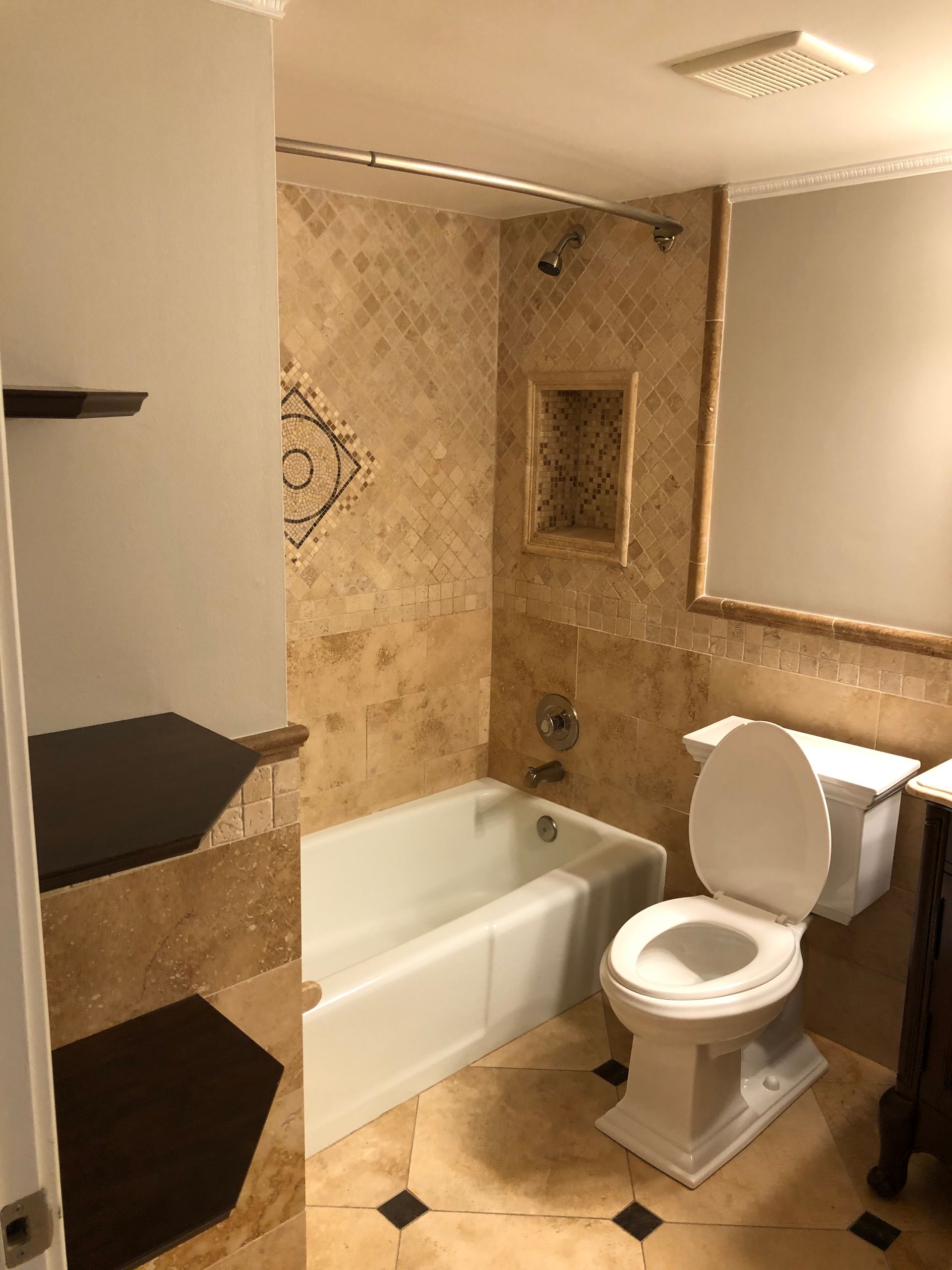 A bathroom with a toilet , bathtub and mirror.