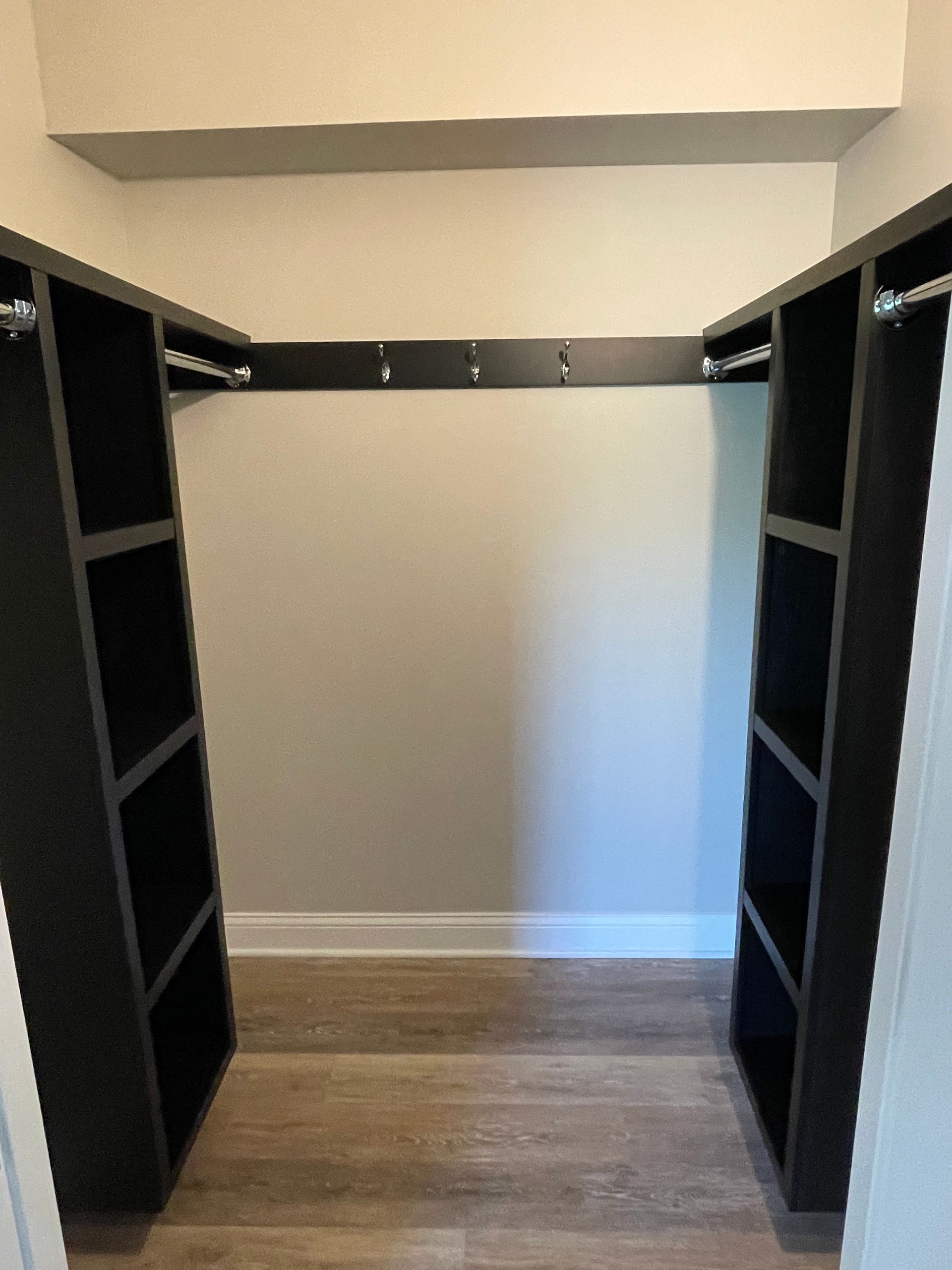 A walk in closet with a lot of shelves and hooks.