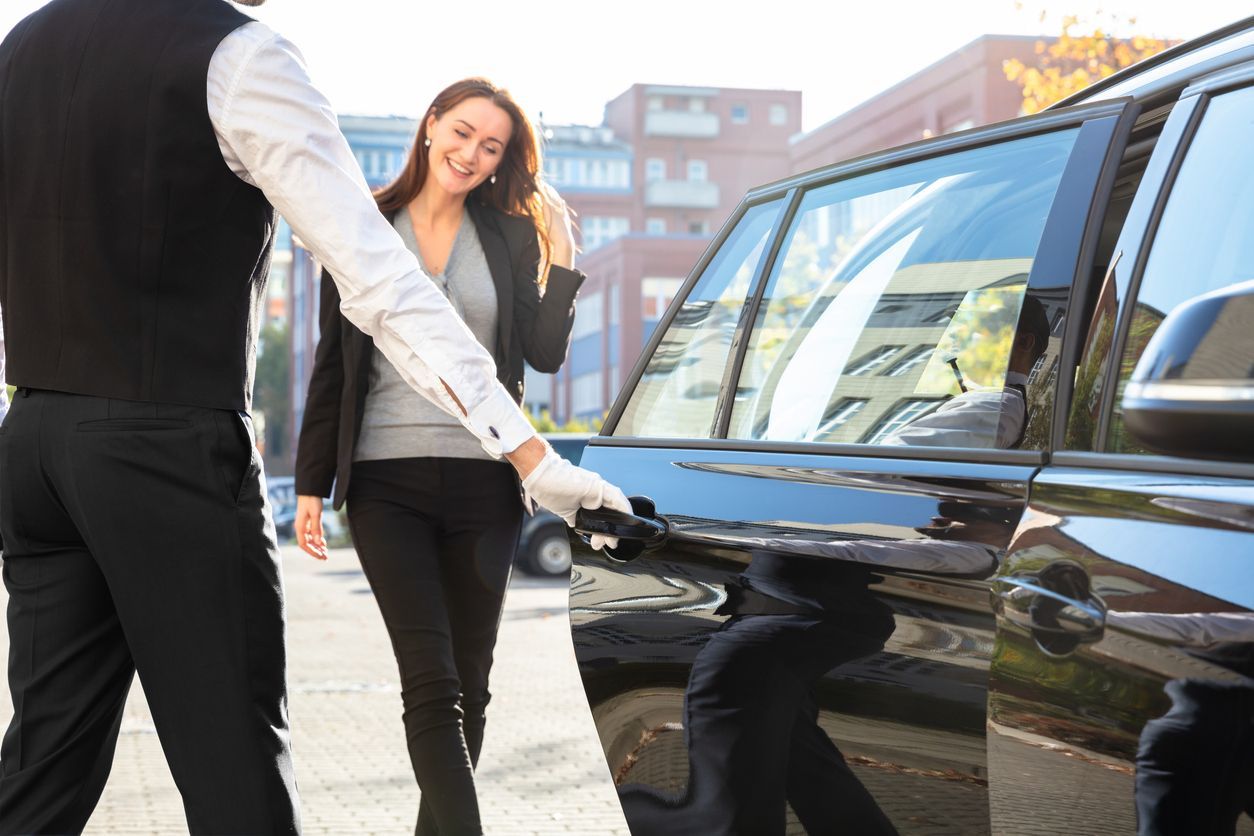 Chauffeur Opening Door For Businesswoman 