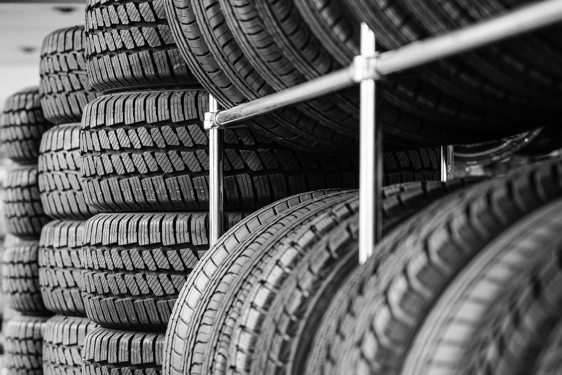 Stacks of tires on metal shelving in a store.