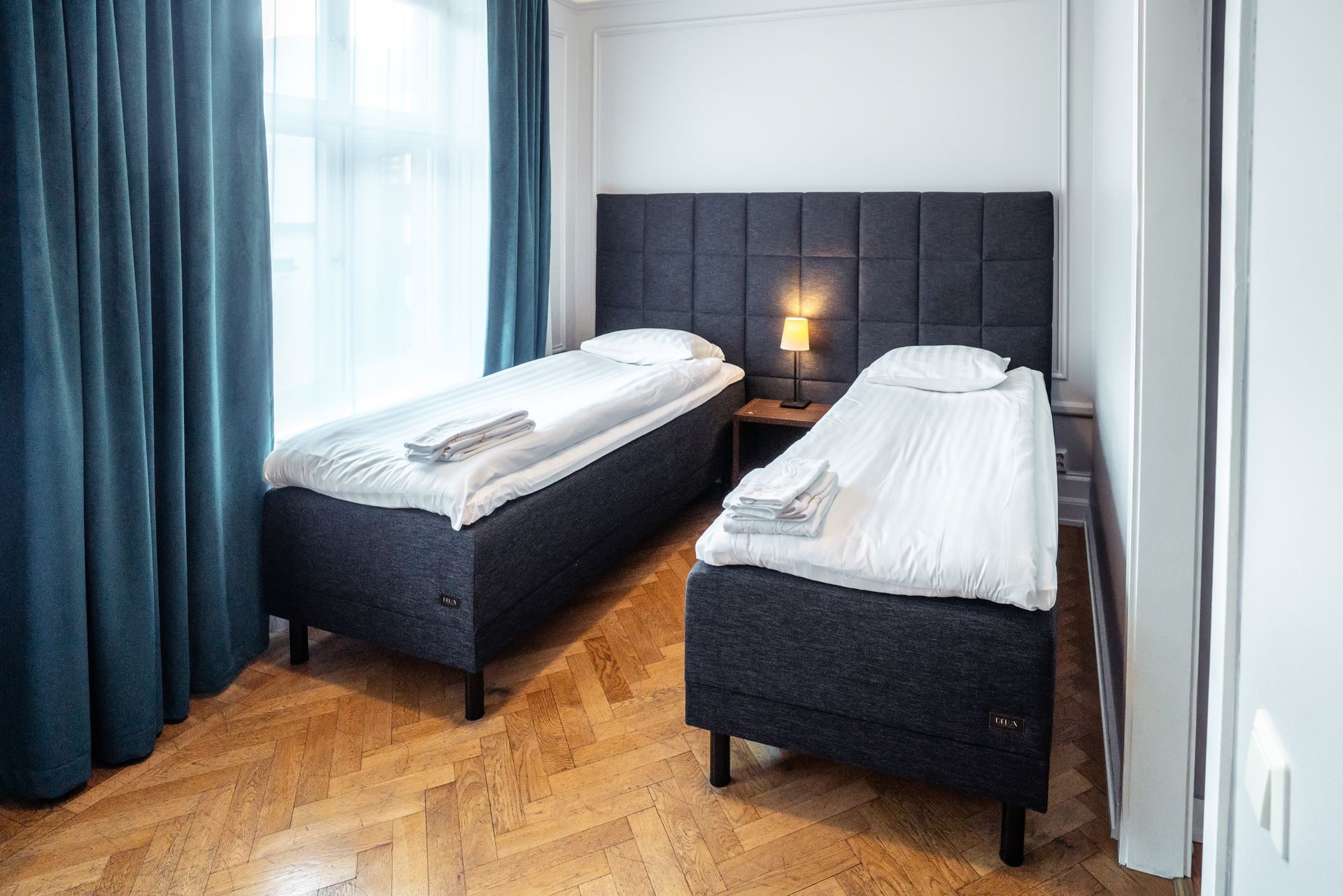 a hotel room with two beds and a window .