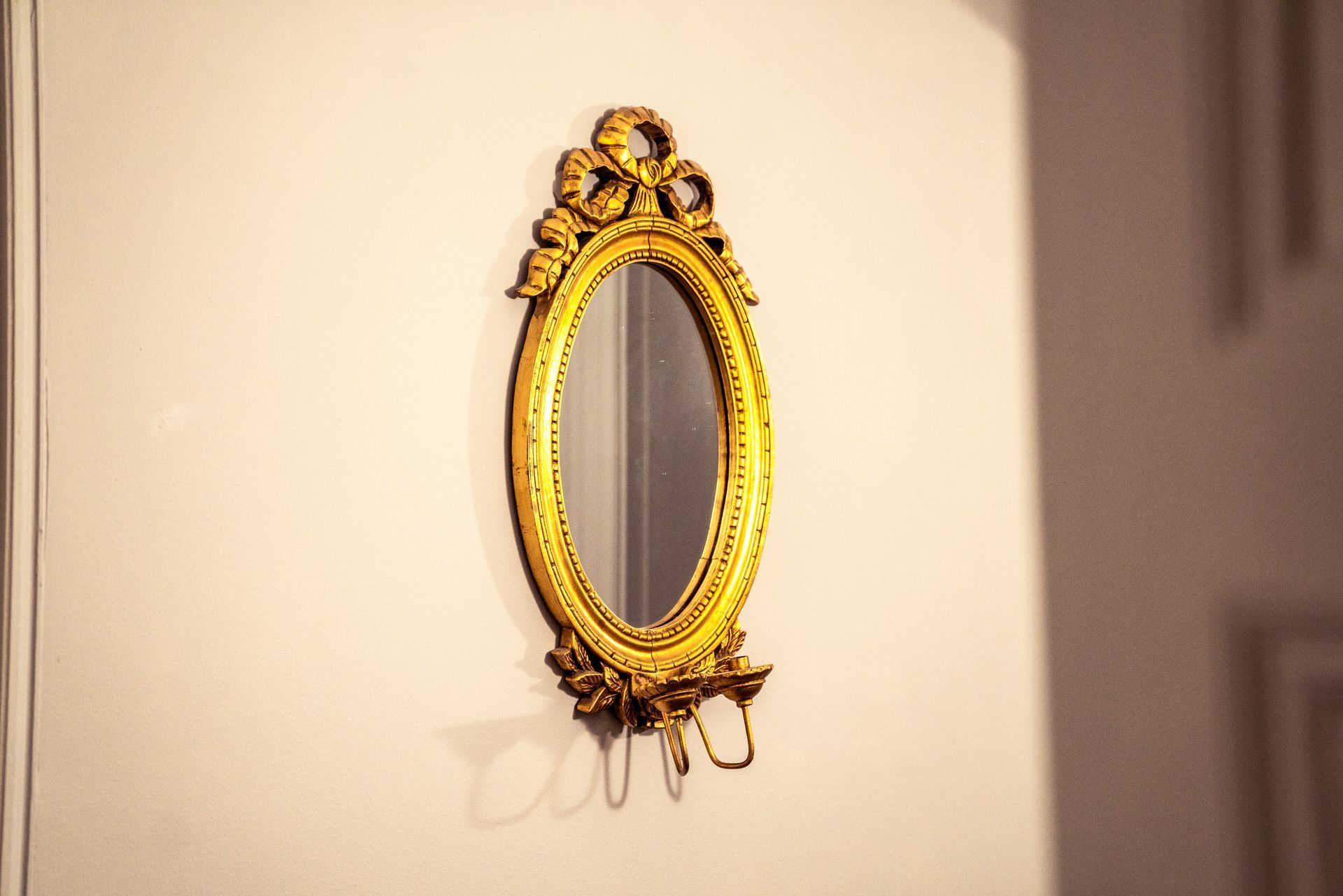 a gold mirror is hanging on a white wall