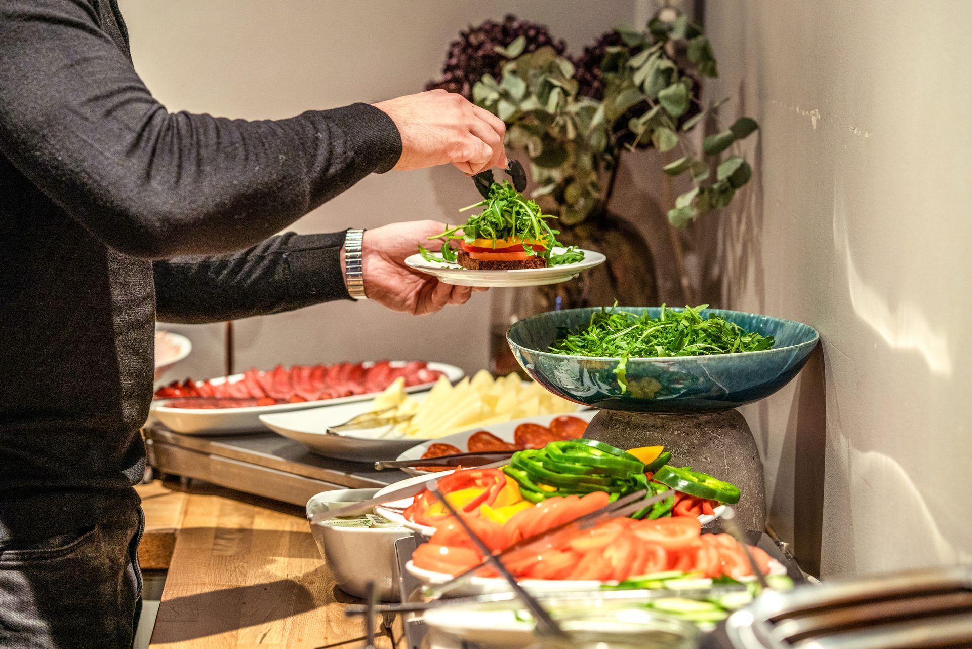 a man is taking a plate of food from a buffet table .