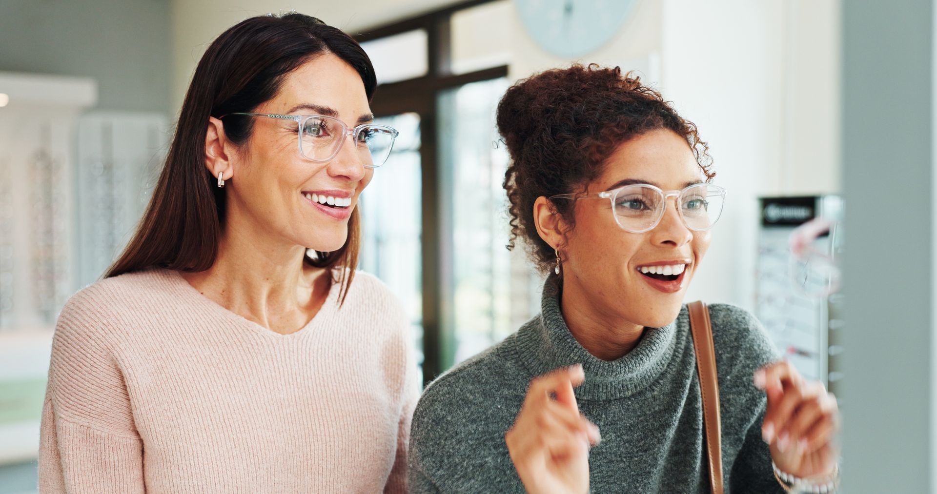 Two women standing indoors, engaged in conversation or discussion.