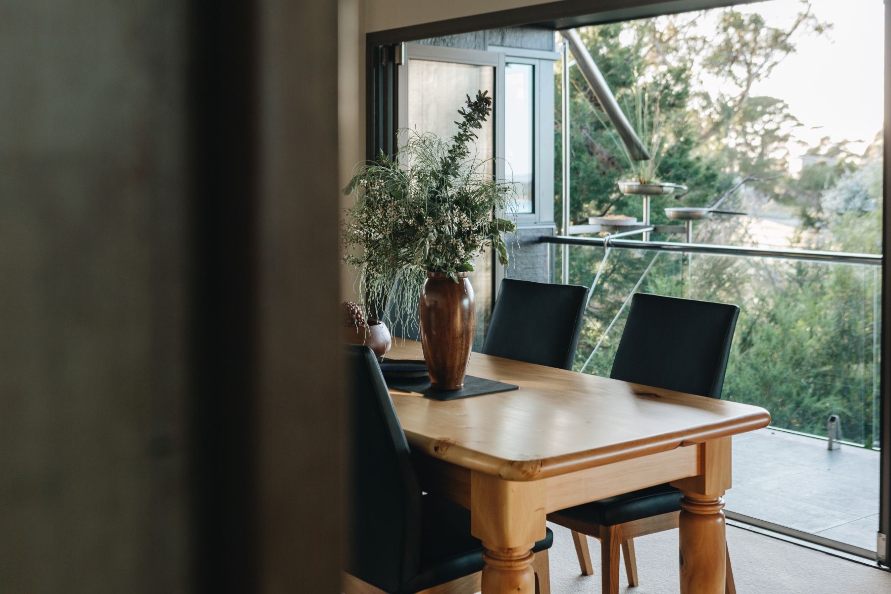 a dining room table and chairs in in dining room which looks onto unique birdbath.