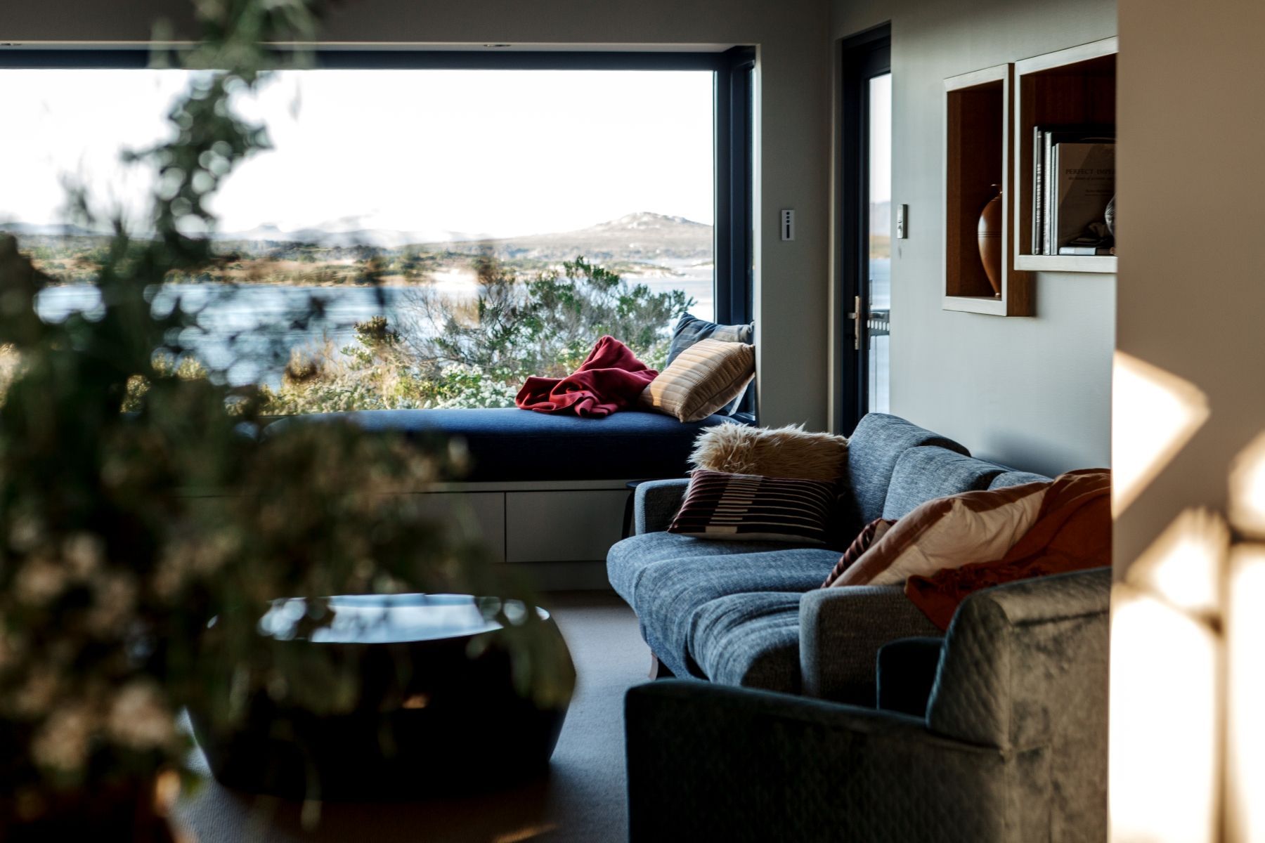 Faraway's living room with couch and a window with a view of the ocean.