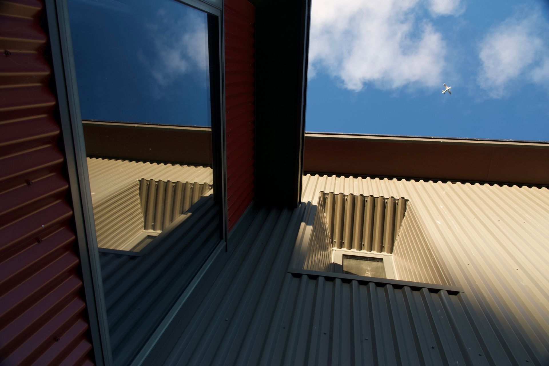 A reflection of a building in a window with a blue sky in the background