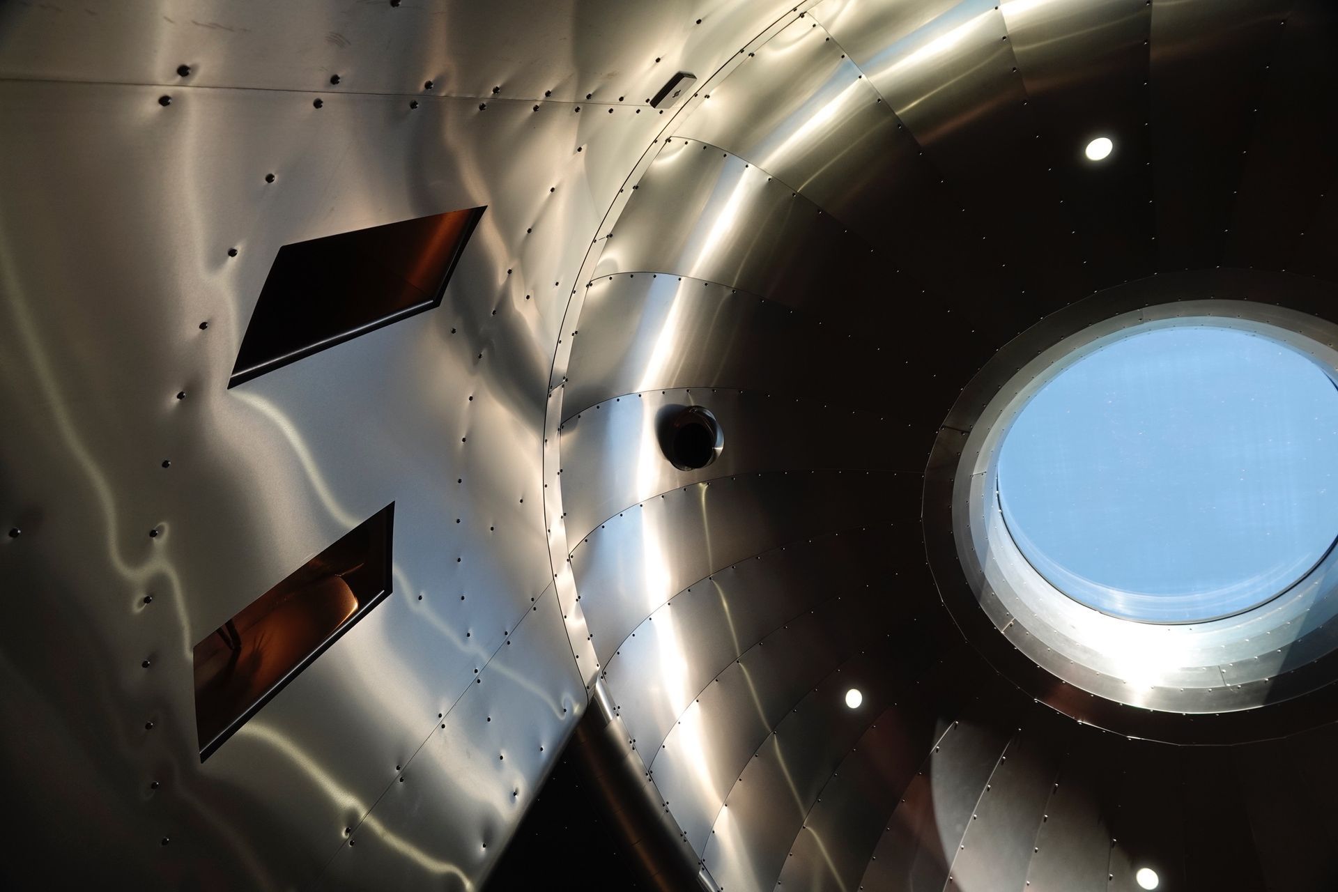 Looking up at a round window in a metal structure