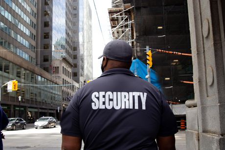 A security guard is walking down a city street