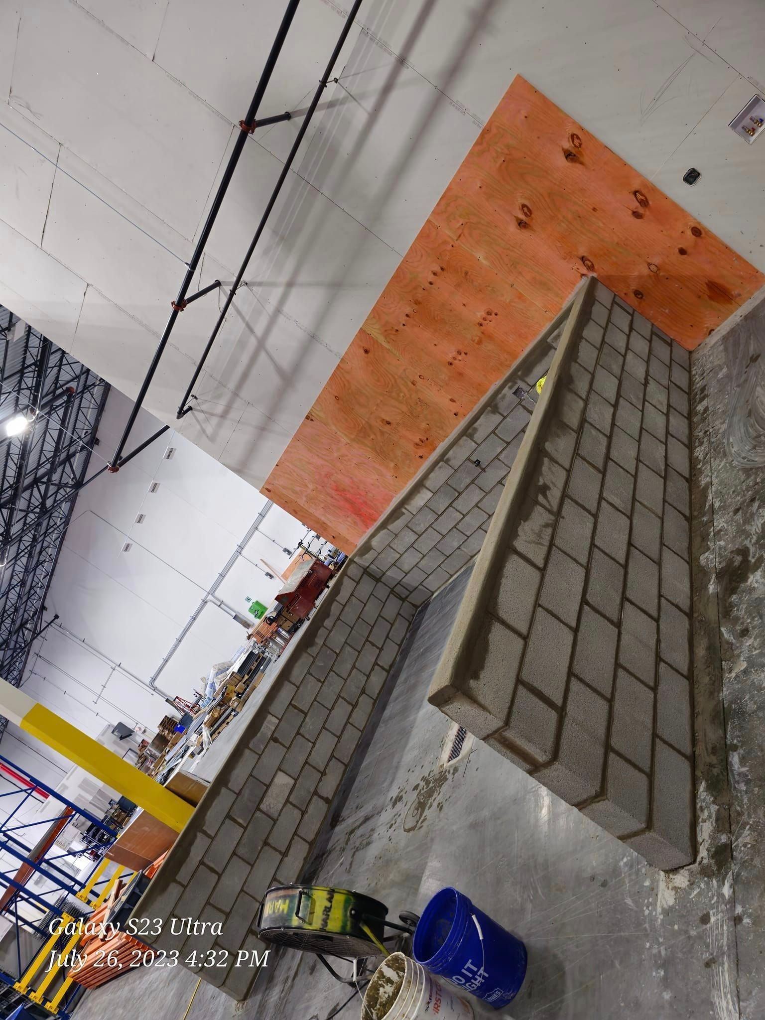 Brick wall angled with plywood backing, likely an indoor construction project.
