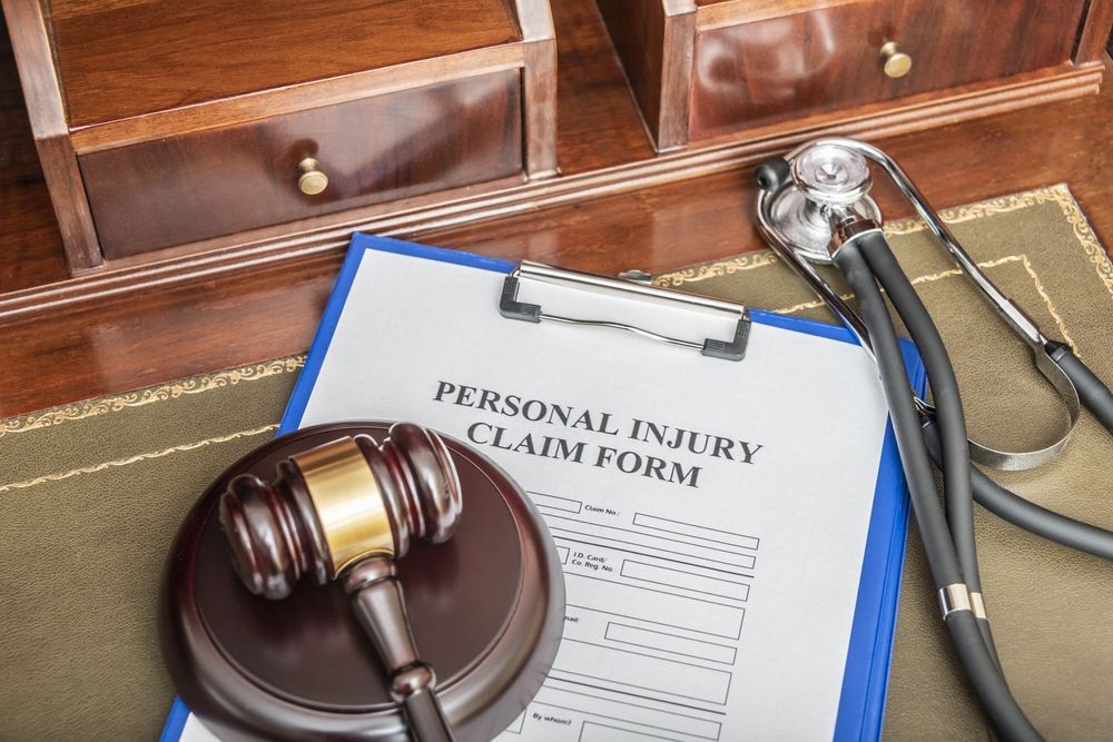 Personal injury claim form with stethoscope and judge gavel